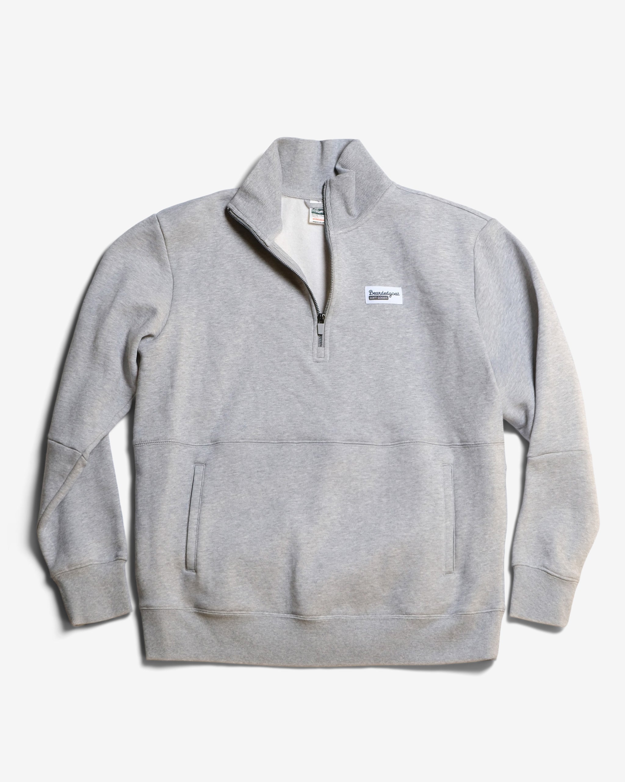 The BEARDEDGOAT NEW — VOID™ Half Zip in heather grey features a stand-up collar, front zipper, two side pockets, and a chest patch, made from premium cotton fleece and displayed flat on a white background.