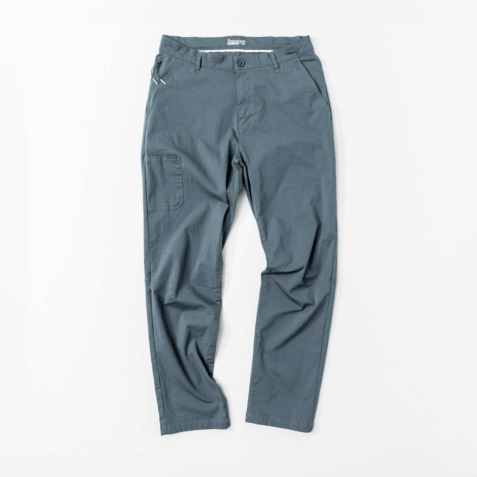 The beardedgoat Mens Union Pant in gray features a straight-leg cut, active fit, belt loops, side pockets, button and zipper closure, plus a right thigh utility pocket. Pants are shown laid flat on a white surface.