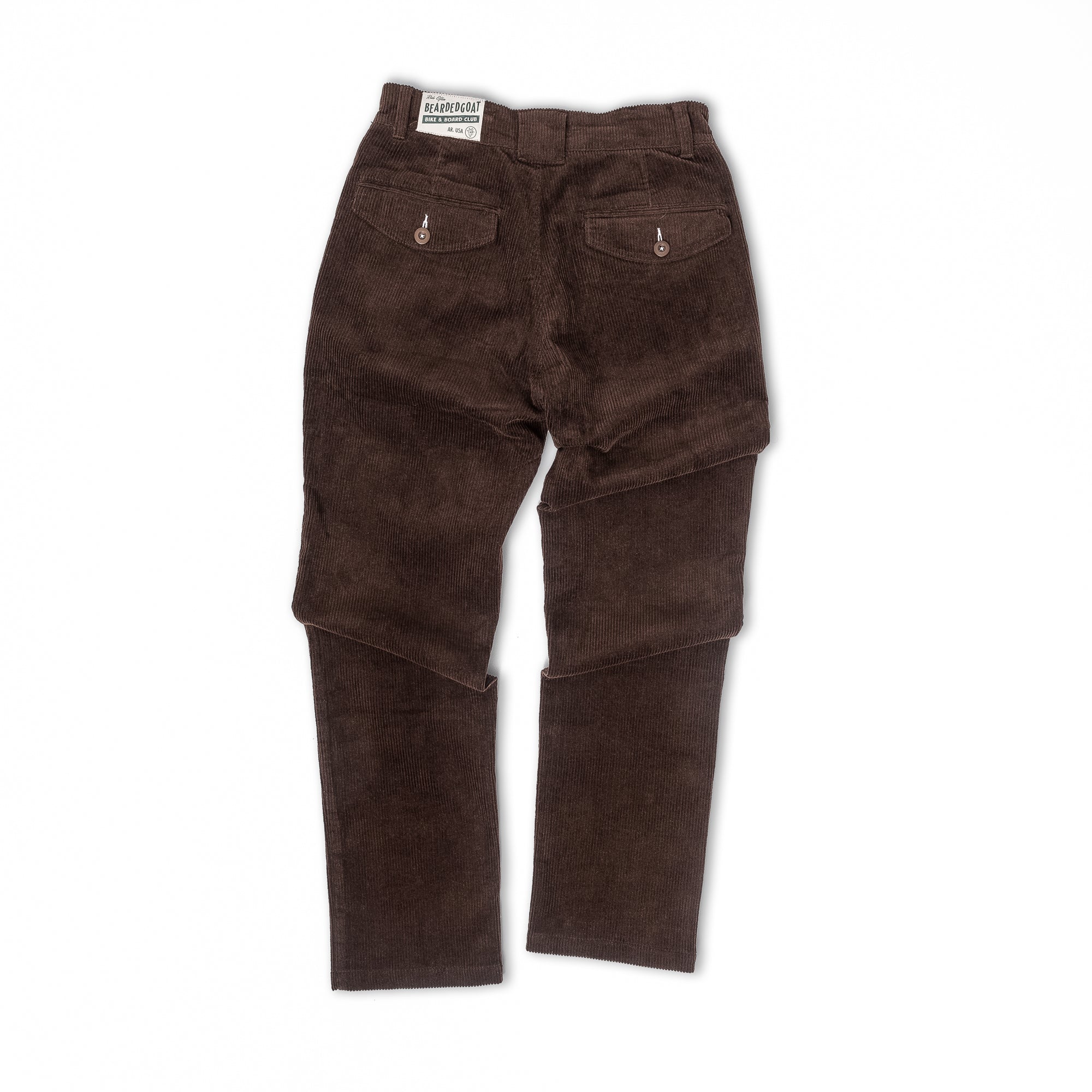 The beardedgoat Mens Moor Corduroy Pant is shown flat on a white background, viewed from the back. These loose fit pants feature two buttoned back pockets and a branded label on the waistband.