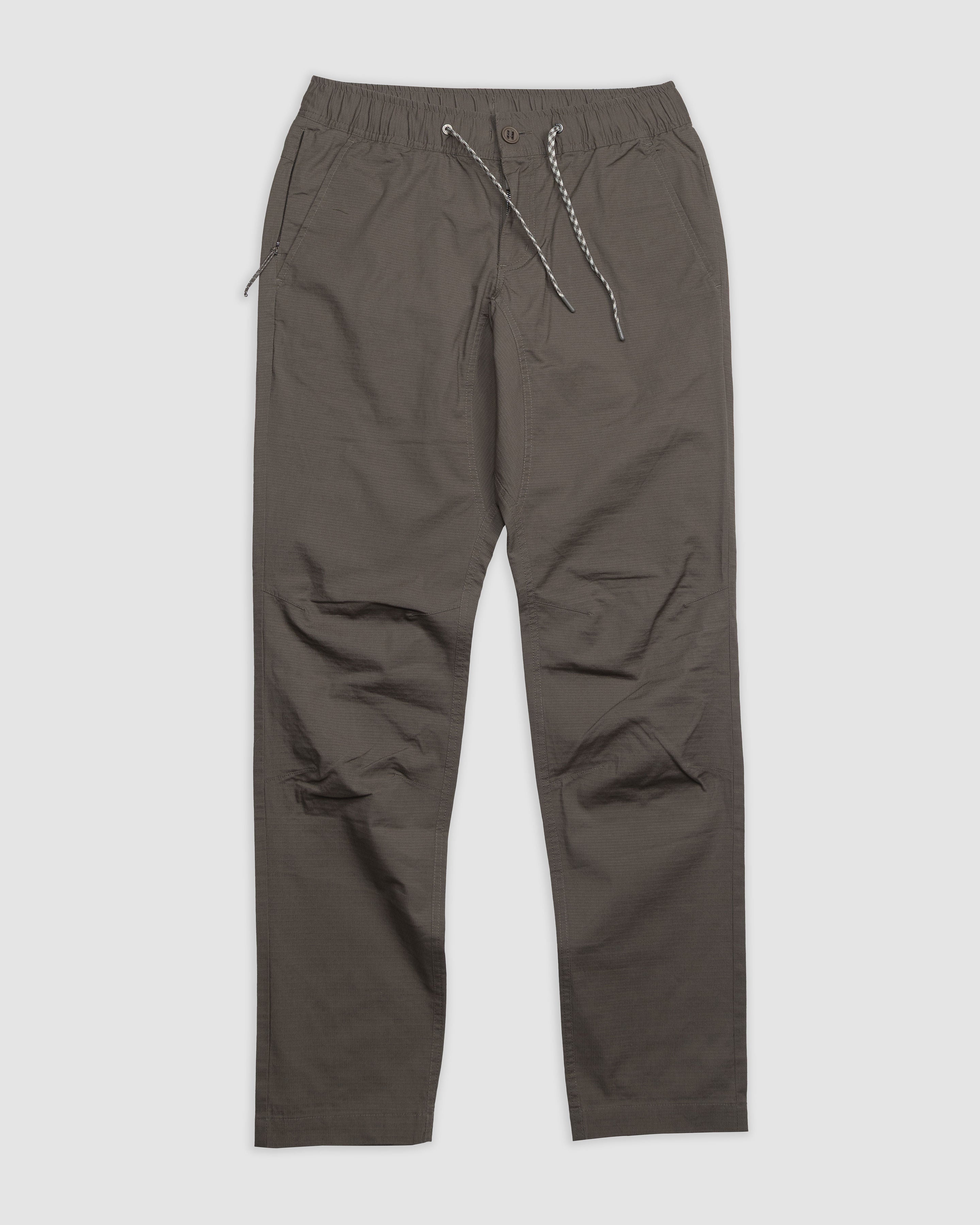 The BEARDEDGOAT Men's Canopy Pant in dark gray features durable ripstop fabric, an elastic waistband, side pockets, and a relaxed fit, shown laid flat on a white background.