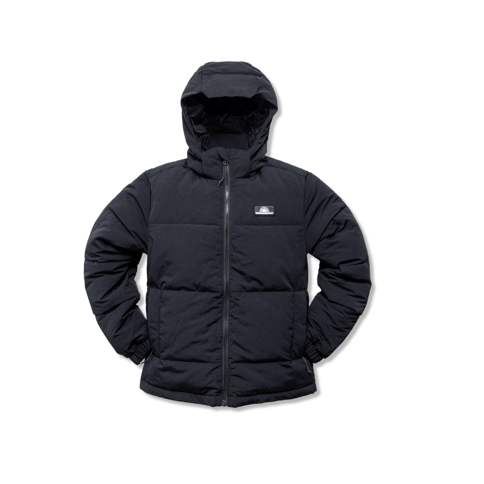 The Womens Wallowa Puffer Jacket by beardedgoat is a black Featherlight™ insulated puffer with a hood, zip front, elastic cuffs, and a small logo patch on the left chest, shown on a white background.