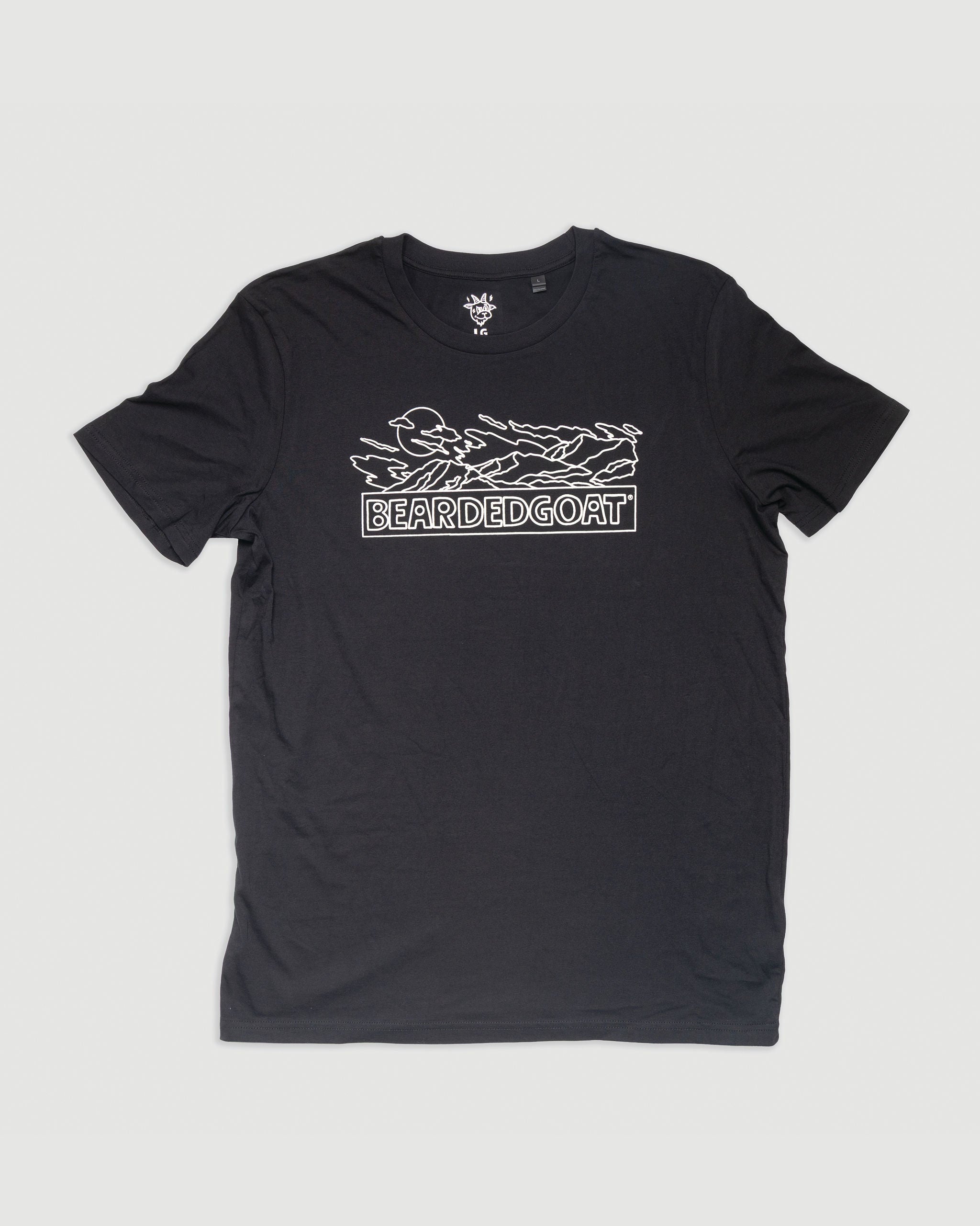 The Moonrise Tee - Black by BEARDEDGOAT features a white line art mountain design and BEARDEDGOAT boldly printed below, shown laid flat on a white background.