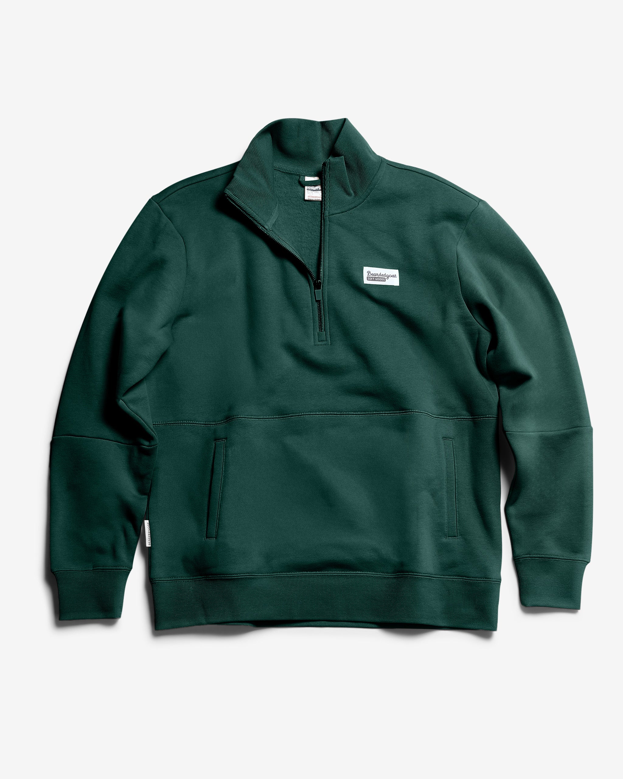 The BEARDEDGOAT NEW — VOID™ Half Zip in Forest is a dark green premium cotton fleece pullover with a high collar, front pockets, and a small rectangular white chest label, shown on a plain white background.