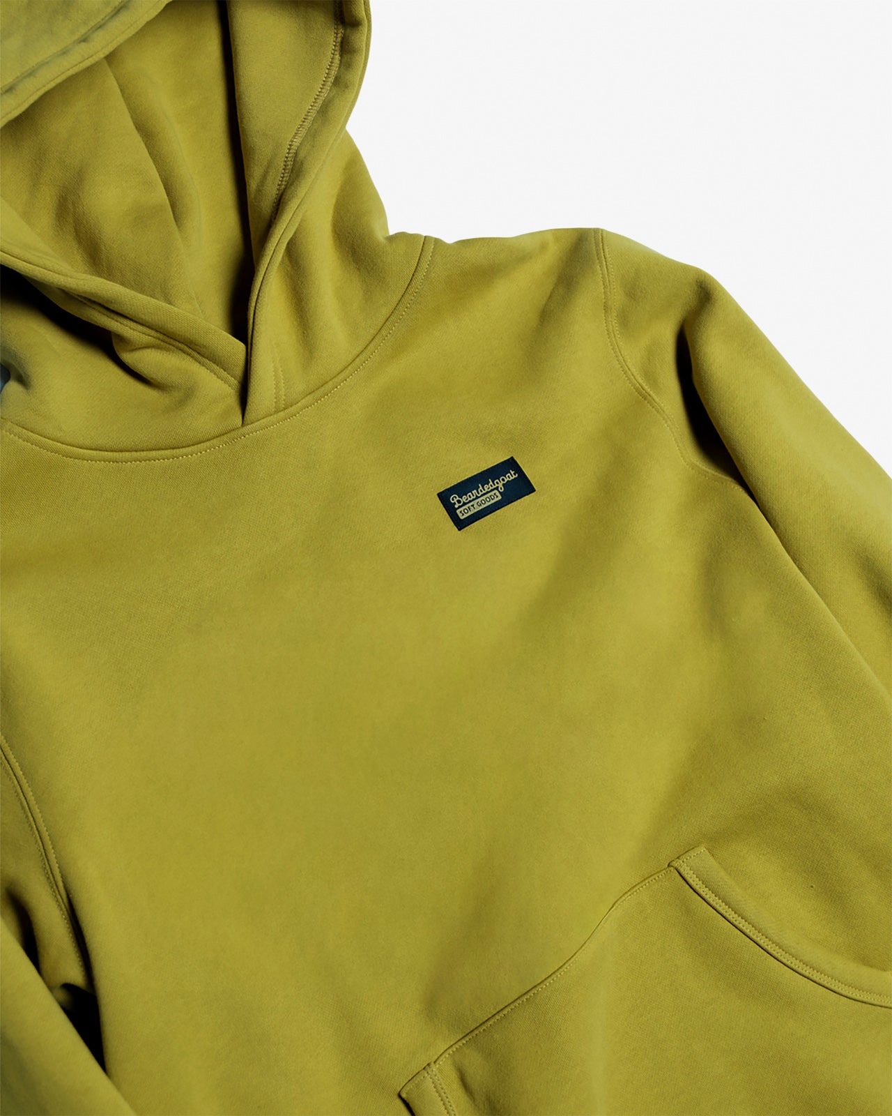 The VOID™ Hoodie by beardedgoat is a lime green men's heavyweight cotton fleece hoodie with a front pocket and a small rectangular navy VOID label on the chest, shown against a white background.