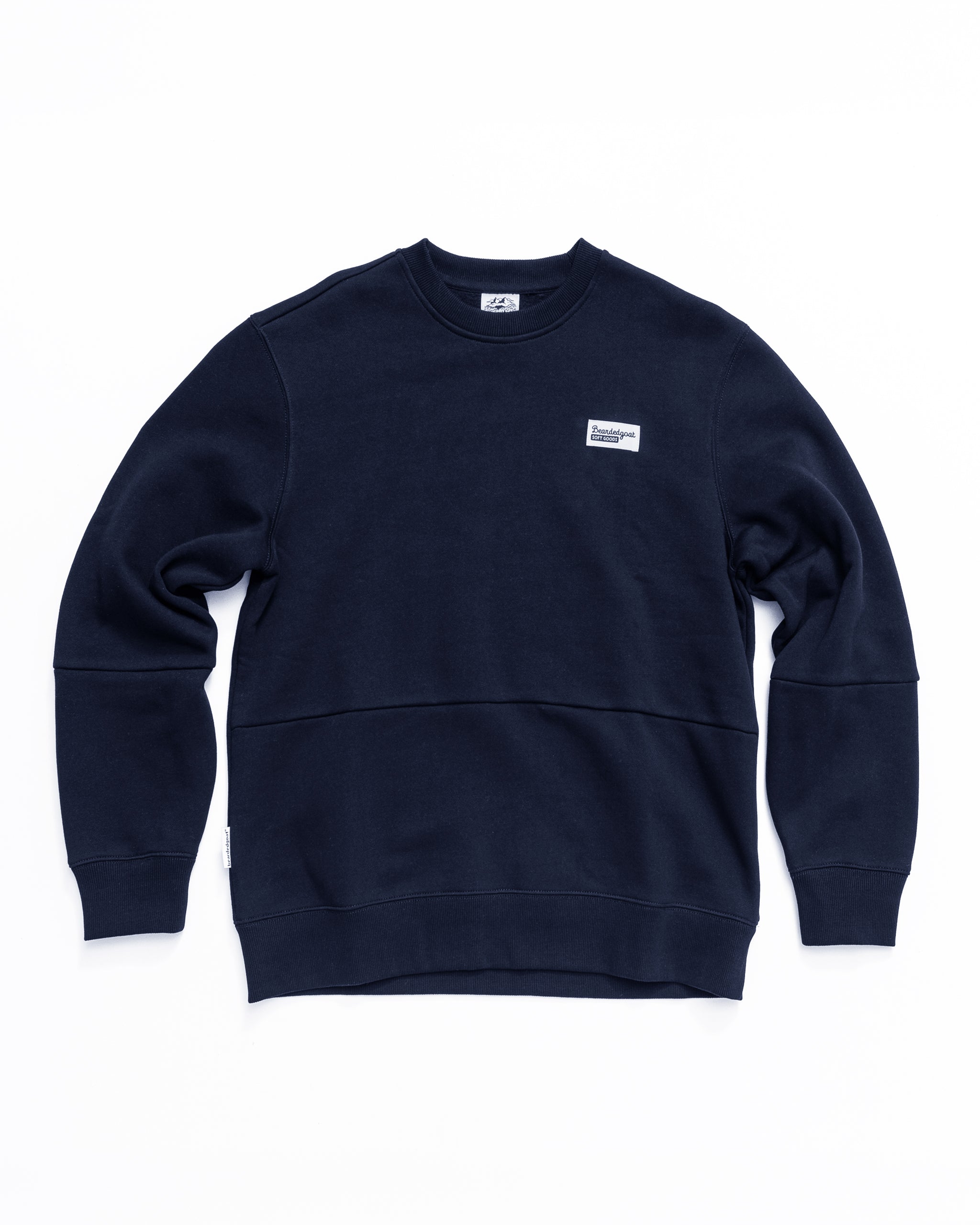 The beardedgoat Men's Void Crew is a heavyweight navy blue crewneck sweatshirt with long sleeves, ribbed cuffs and hem, and a small rectangular white patch on the left chest, shown laid flat on a white background.