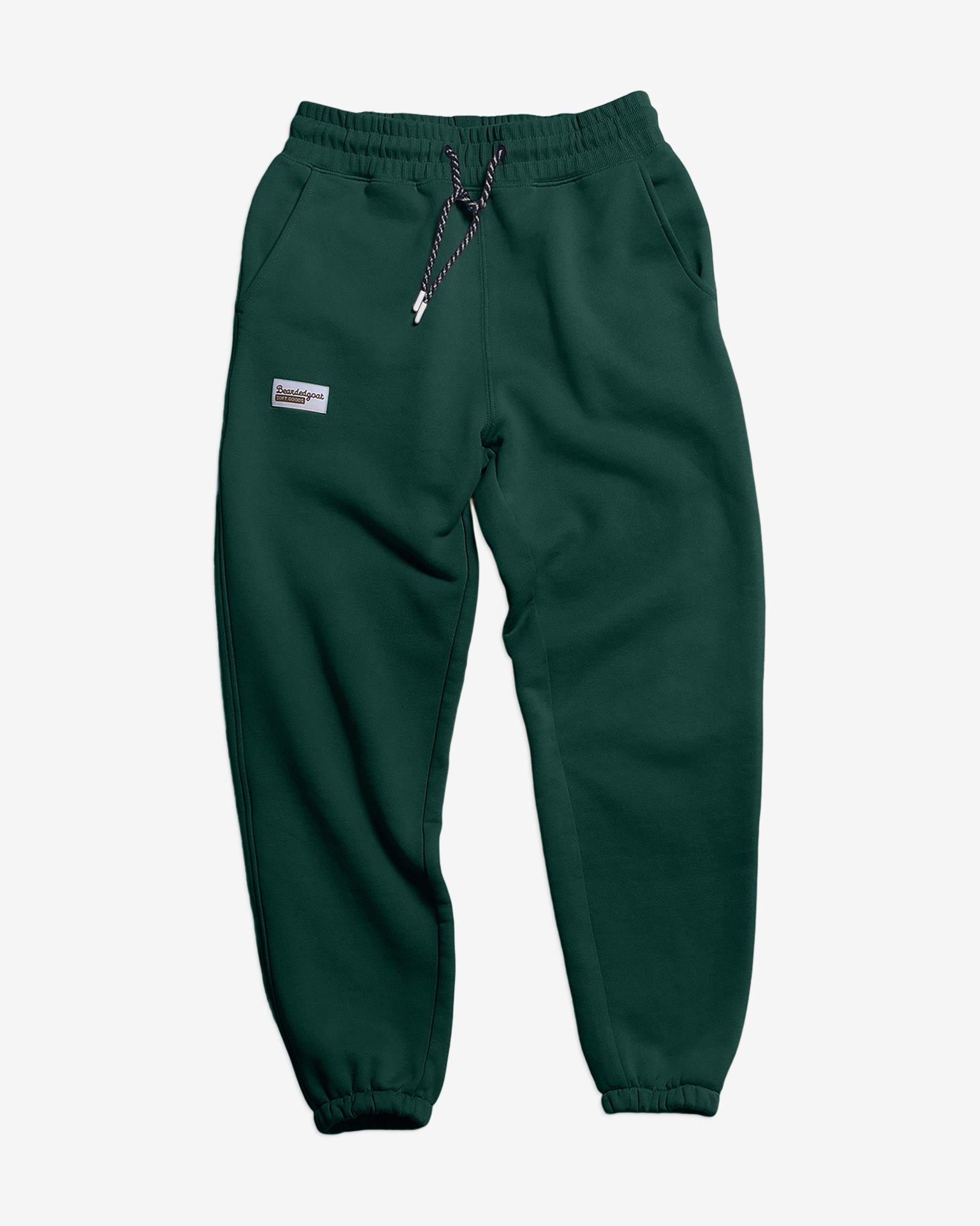BEARDEDGOAT Women’s Overnight™ Classic Jogger in dark green, crafted from heavyweight cotton fleece with a high-rise elastic waistband, black-and-white drawstring, side pockets, and a small rectangular label on the left thigh.