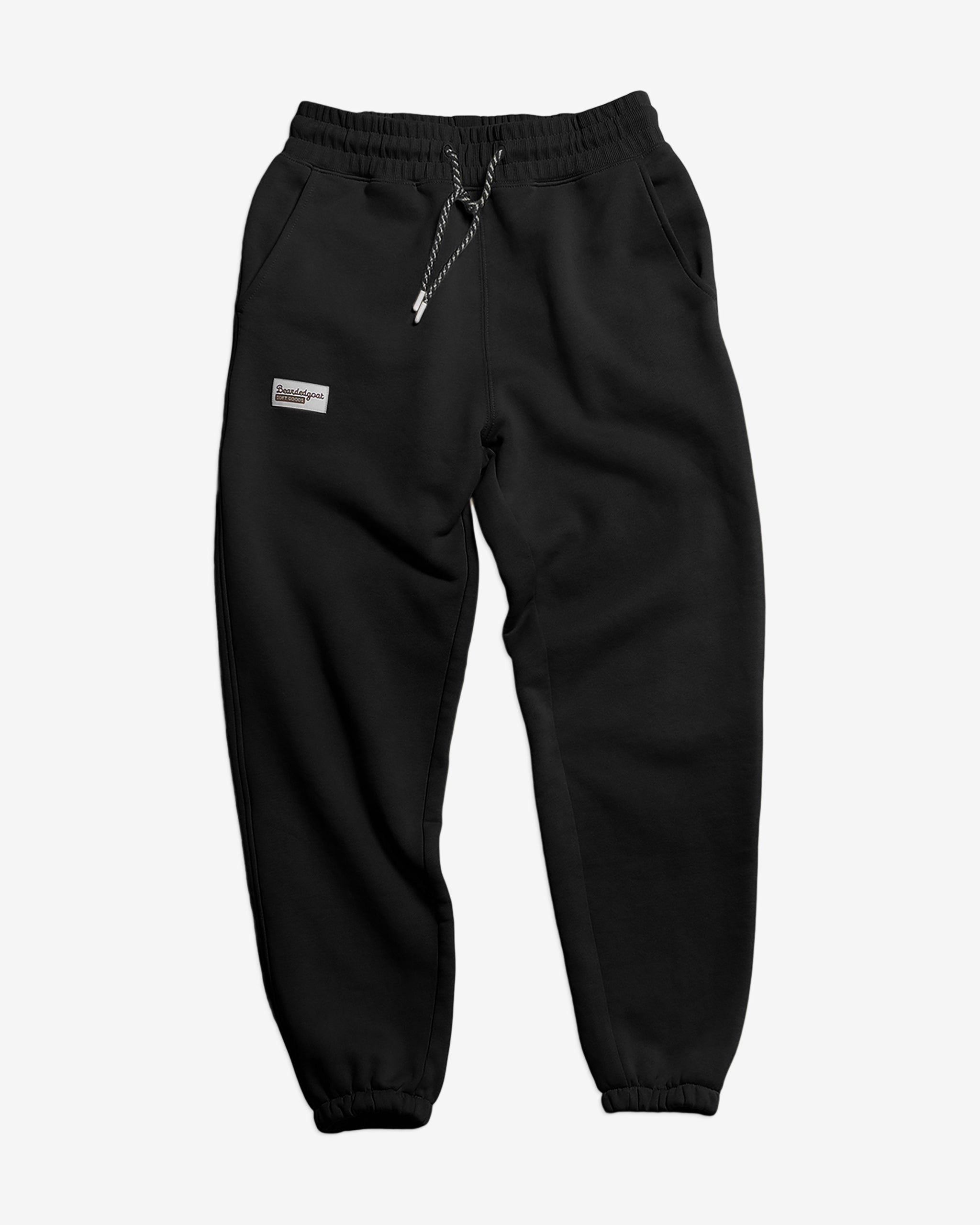 The BEARDEDGOAT NEW — Overnight™ Classic Jogger is a black heavyweight cotton fleece sweatpant with a high-rise waistband, drawstring, side pockets, and a small rectangular label on the left pocket, shown on a white background.