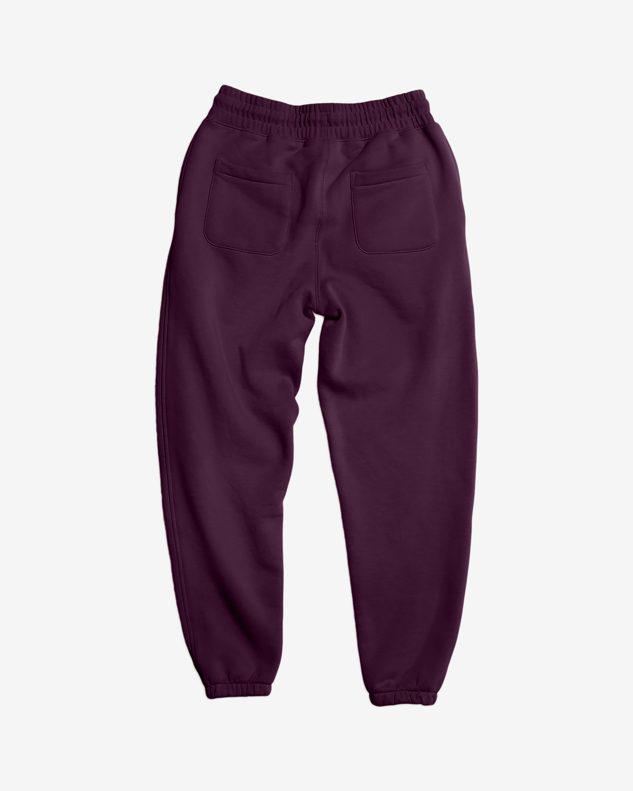 The BEARDEDGOAT NEW — Overnight™ Classic Jogger in dark purple is shown from the back, featuring a high-rise waistband, cuffed ankles, and two square back pockets in heavyweight cotton fleece on a white background.