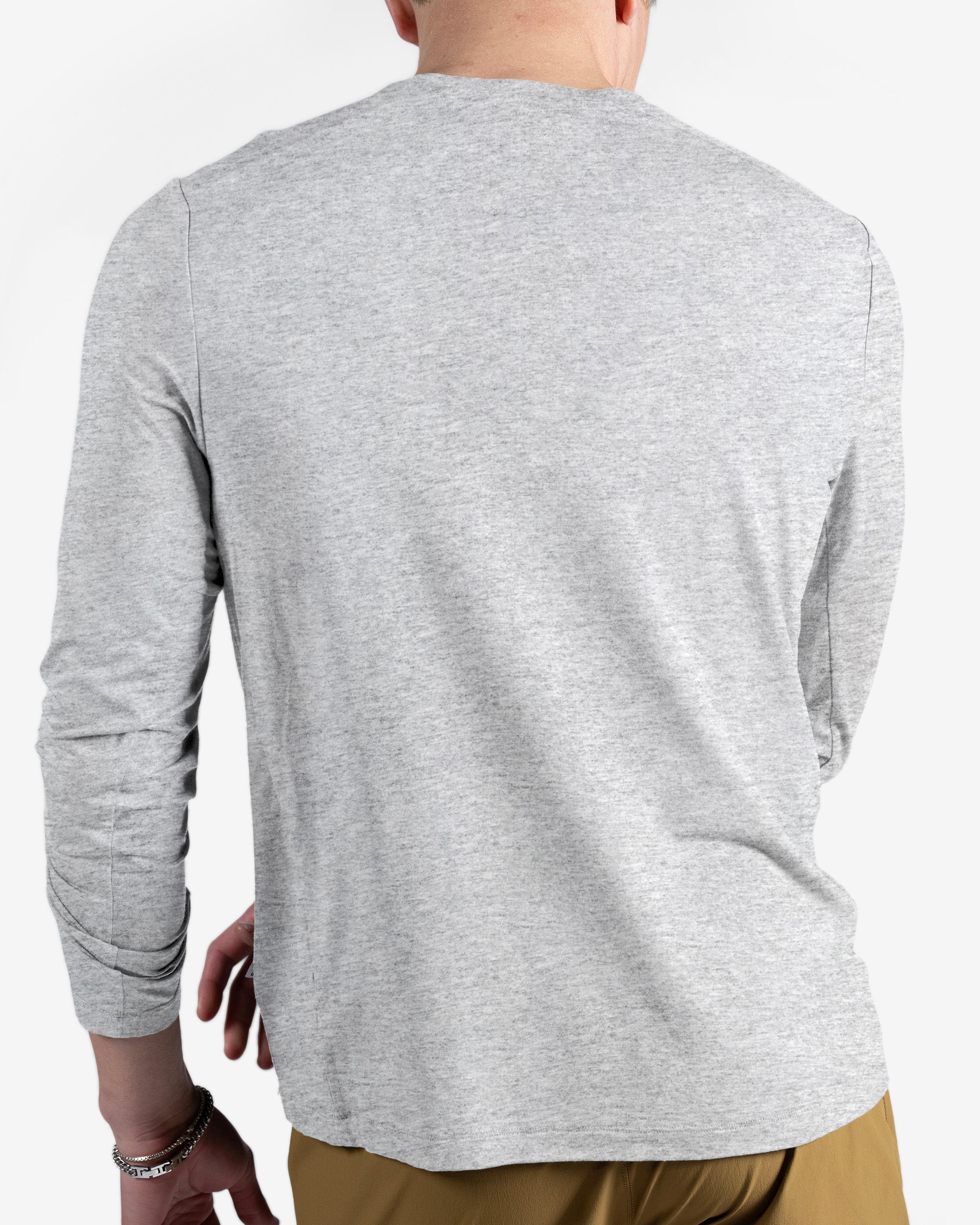 A person is shown from the back wearing a light gray BEARDEDGOAT Men’s EverZen™ Long Sleeve and tan pants, paired with a bracelet on their left wrist. They have short hair and are set against a plain white background.