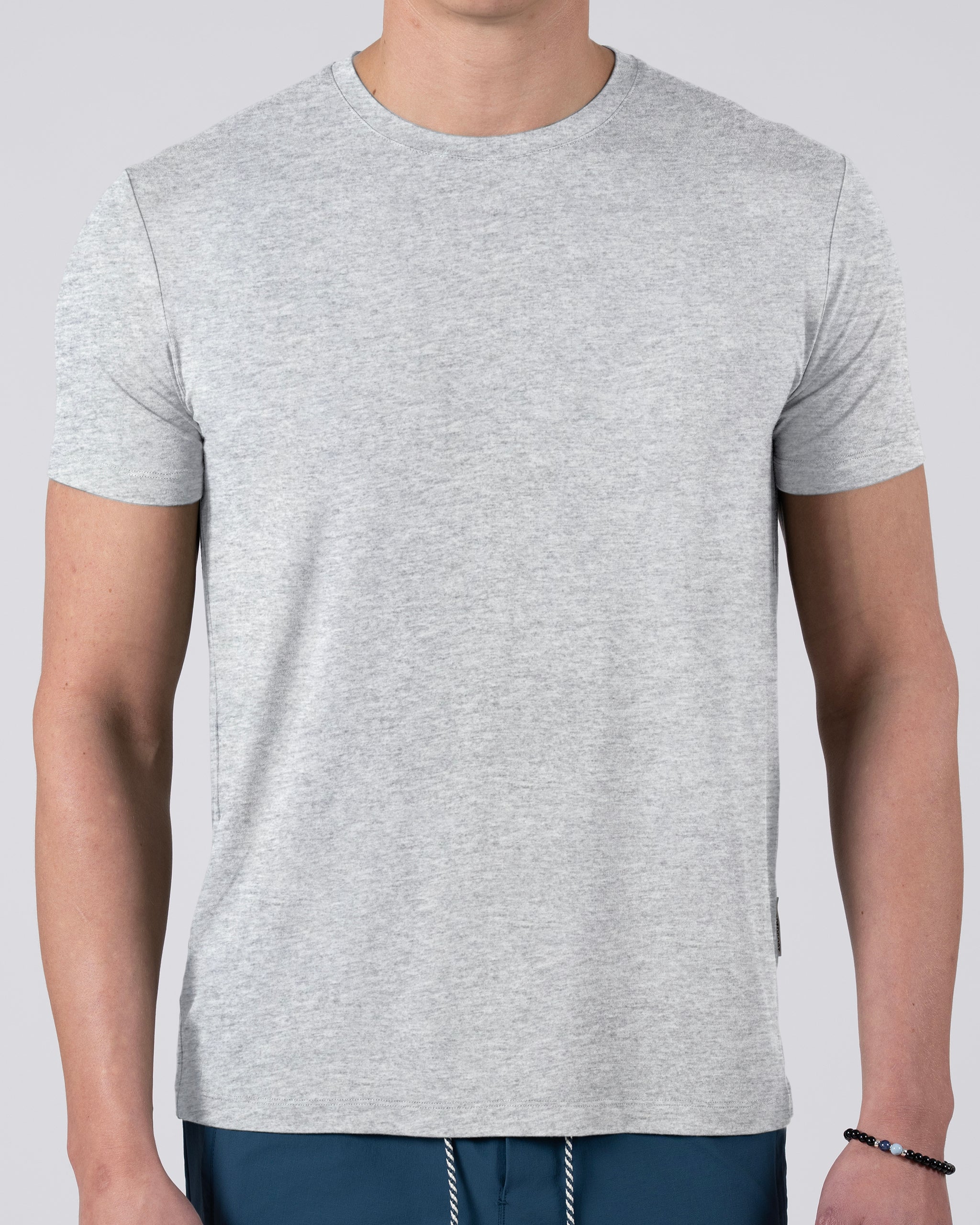 A person wearing a light gray BEARDEDGOAT Men’s EverZen™ Short Sleeve crew neck t-shirt and blue pants, made from a soft bamboo blend for comfort, stands against a plain light background with their head not visible.