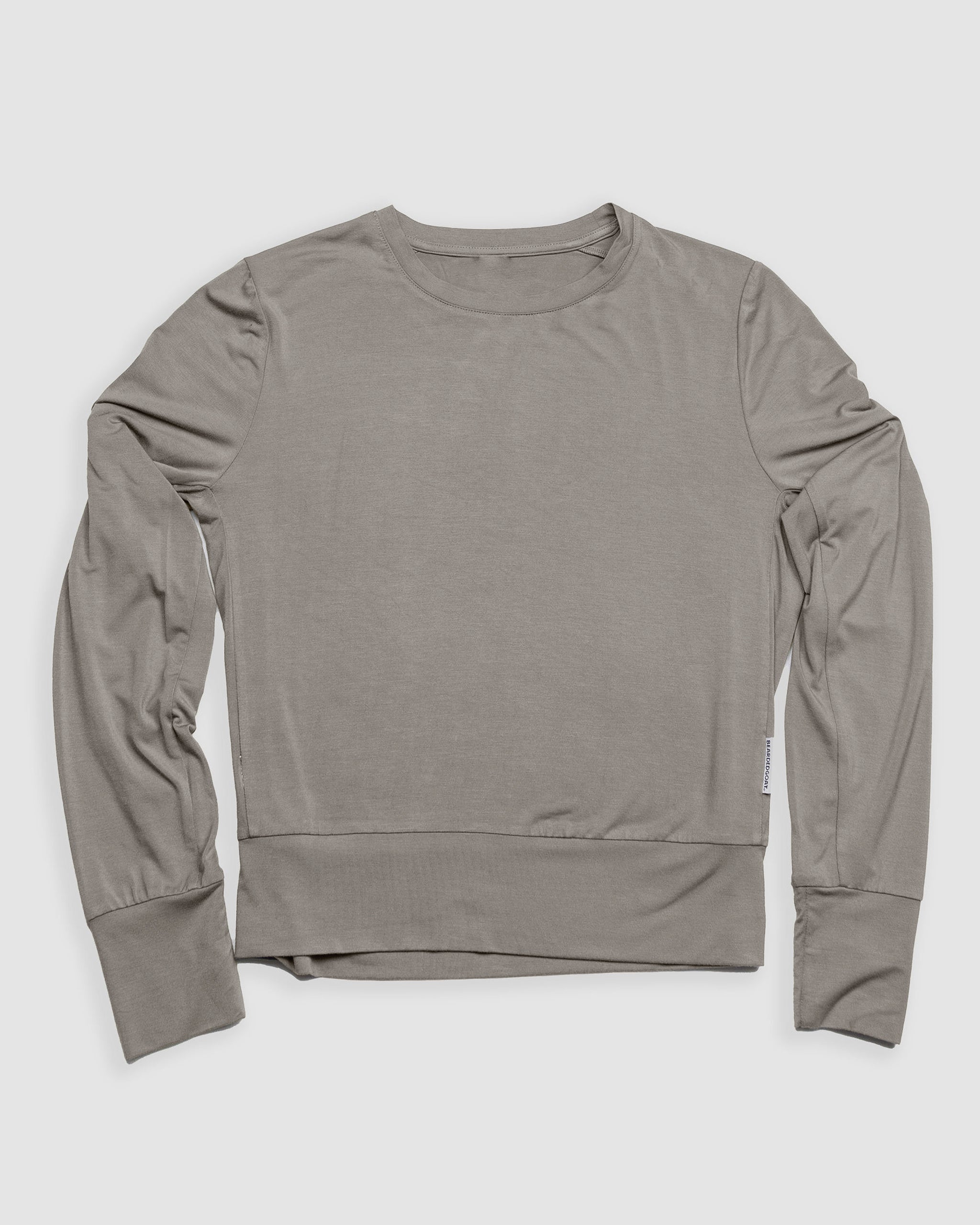 The BEARDEDGOAT Women’s EverZen™ Bamboo Long Sleeve in light grey is laid flat on a white background. This crew neck shirt offers a relaxed fit, ribbed cuffs and waistband, and is made from a sustainable bamboo blend.