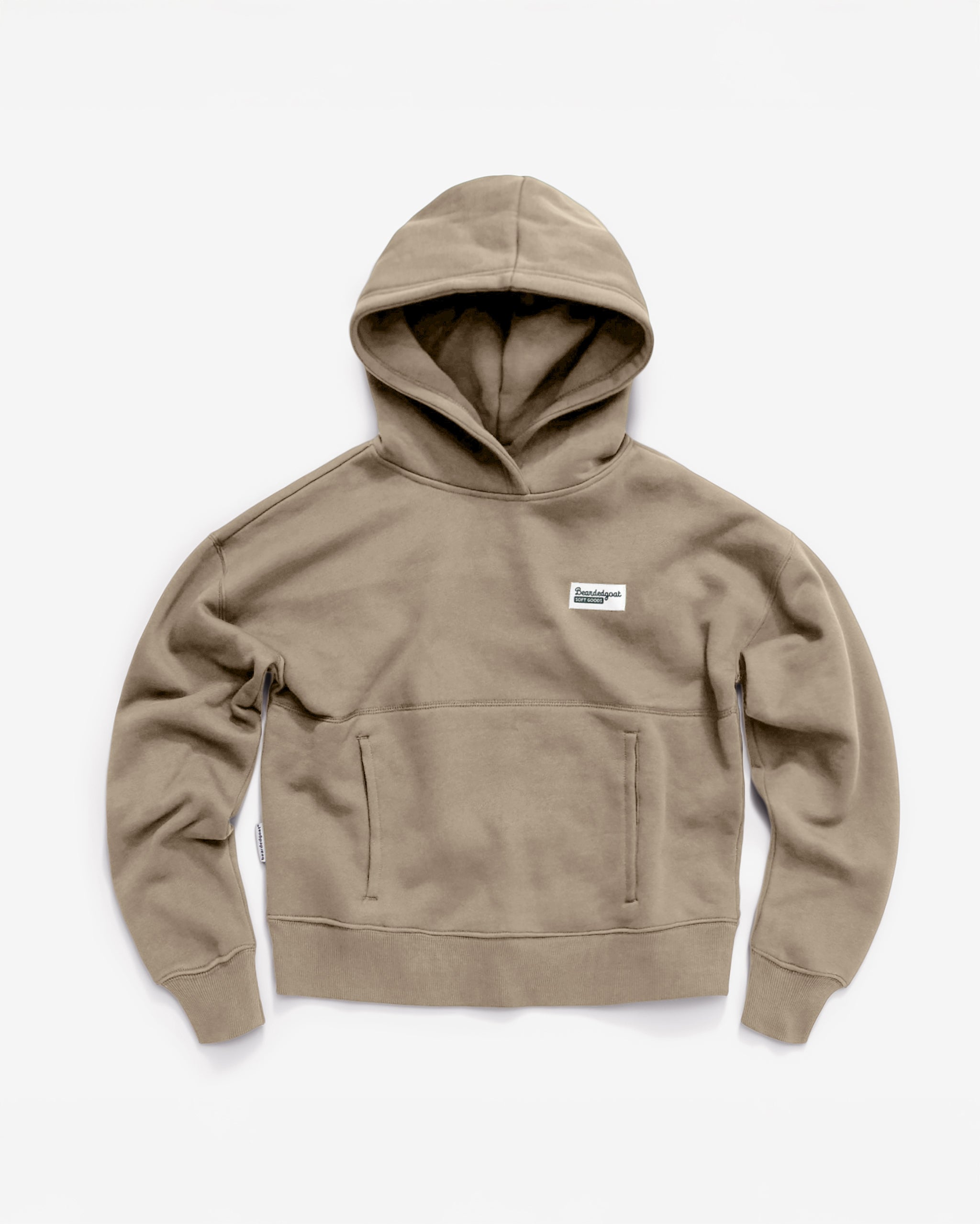 The Women's Overnight™ Hoodie by beardedgoat is khaki-colored, crafted from premium cotton fleece with a front pocket and a small white rectangular chest patch, shown against a plain white background.