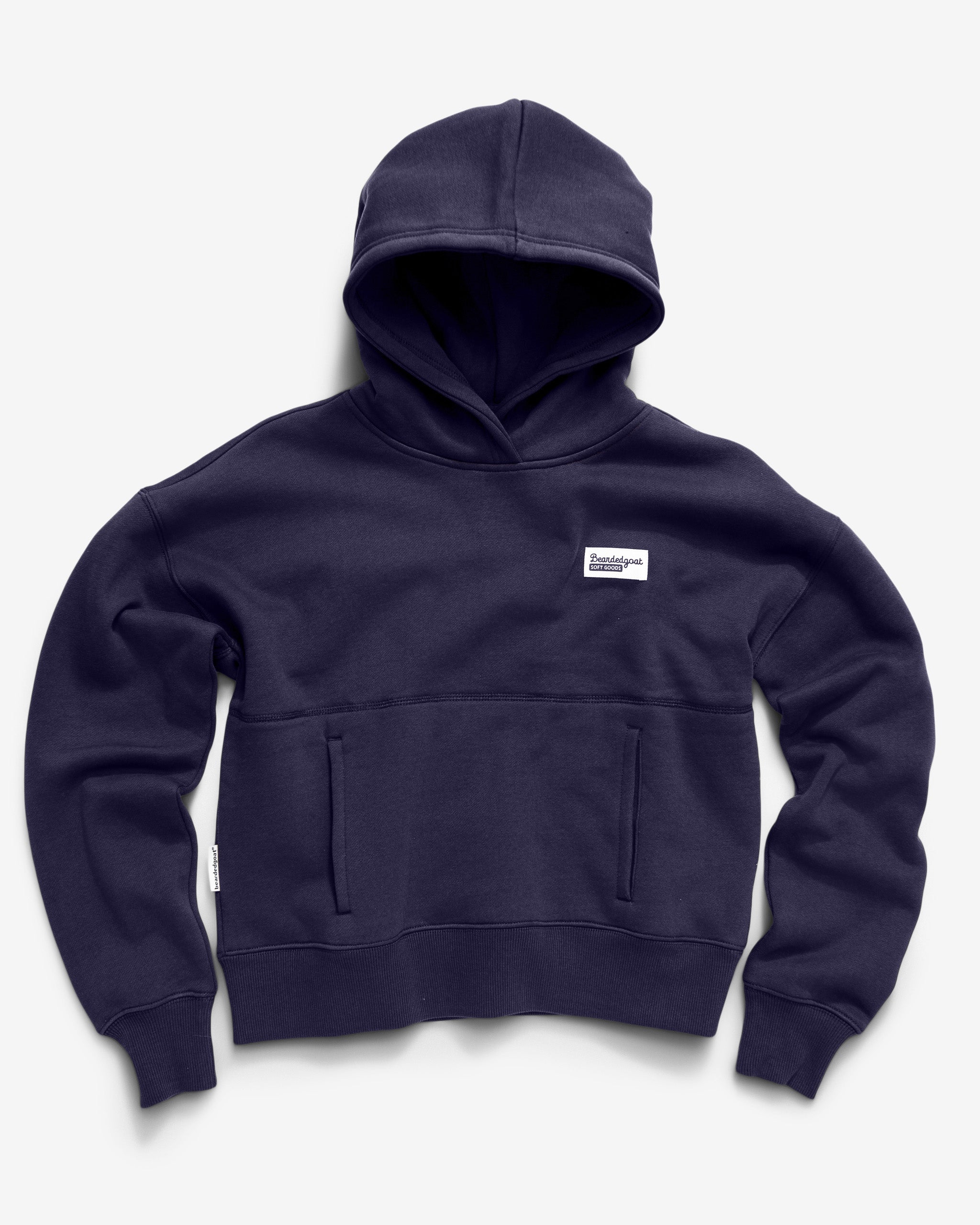 The beardedgoat Women's Overnight™ Hoodie in navy blue premium cotton fleece features a relaxed fit, front pocket, and a small white rectangular patch on the left chest, displayed flat on a light background.
