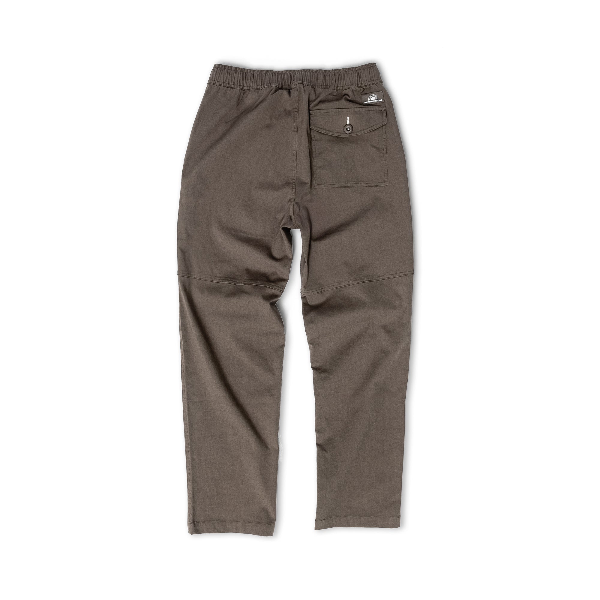 The beardedgoat Mens Dock Pant in olive green is shown from the back, featuring a relaxed fit, elastic drawcord waist, right-side buttoned back pocket, and straight legs.