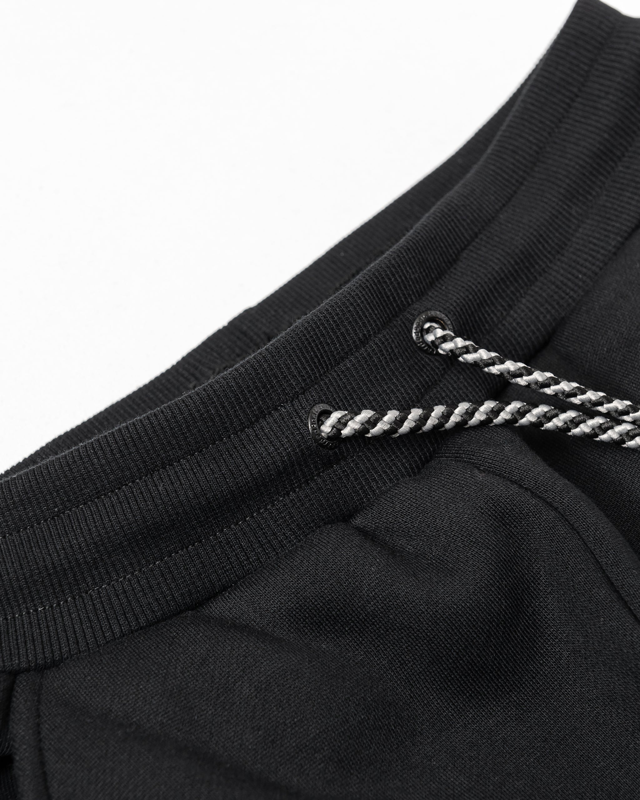 Close-up of the waistband on beardedgoat’s Women’s Overnight Sweatpant, featuring a ribbed elastic band, black-and-white braided drawstrings, and heavyweight cotton fleece for soft comfort—ideal for lounging.