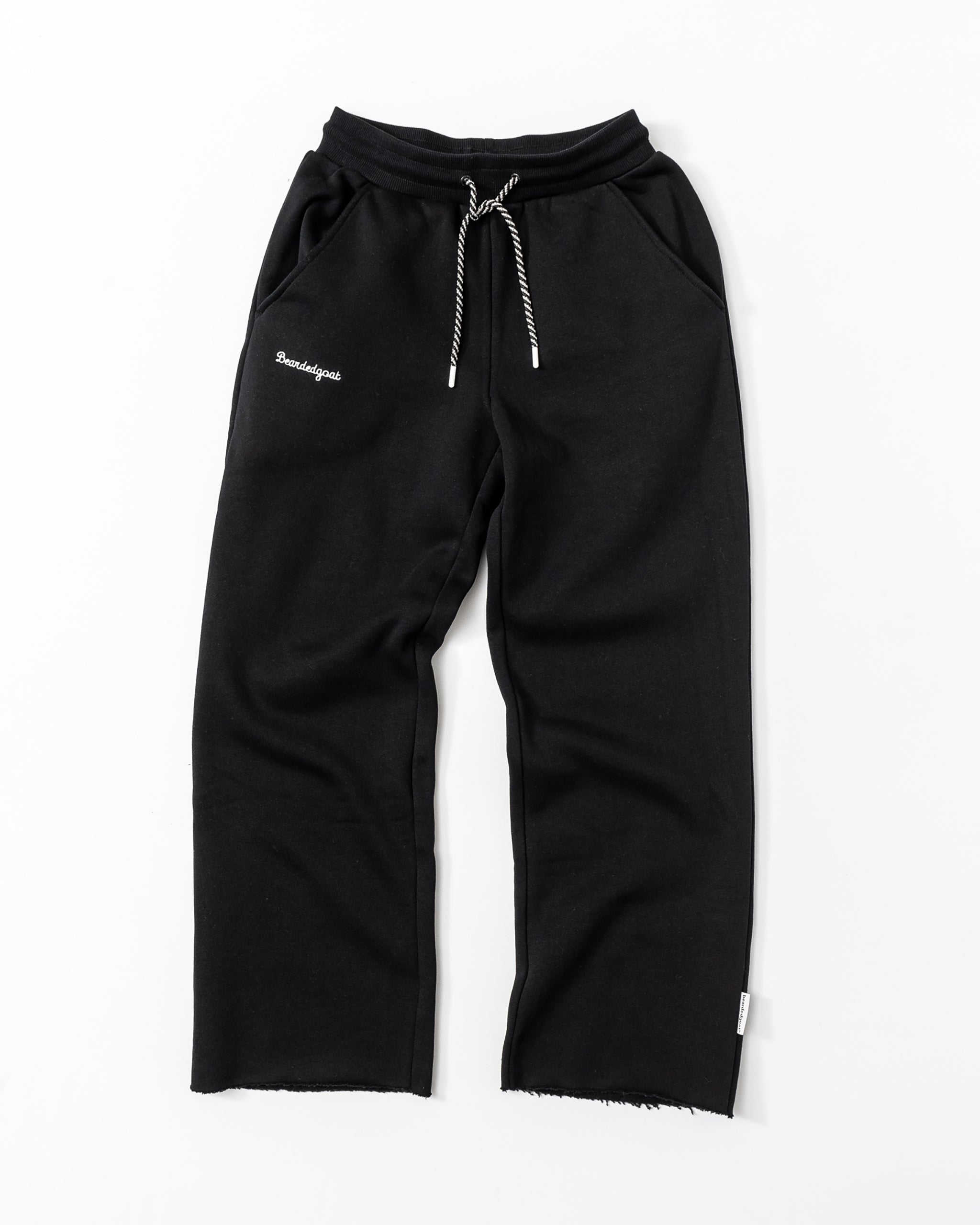 The beardedgoat Women’s Overnight Sweatpant, made from heavyweight cotton fleece with a white drawstring, slanted pockets, and “Bouclique” embroidery on the left pocket, is perfect for comfortable loungewear. Shown on a white background.