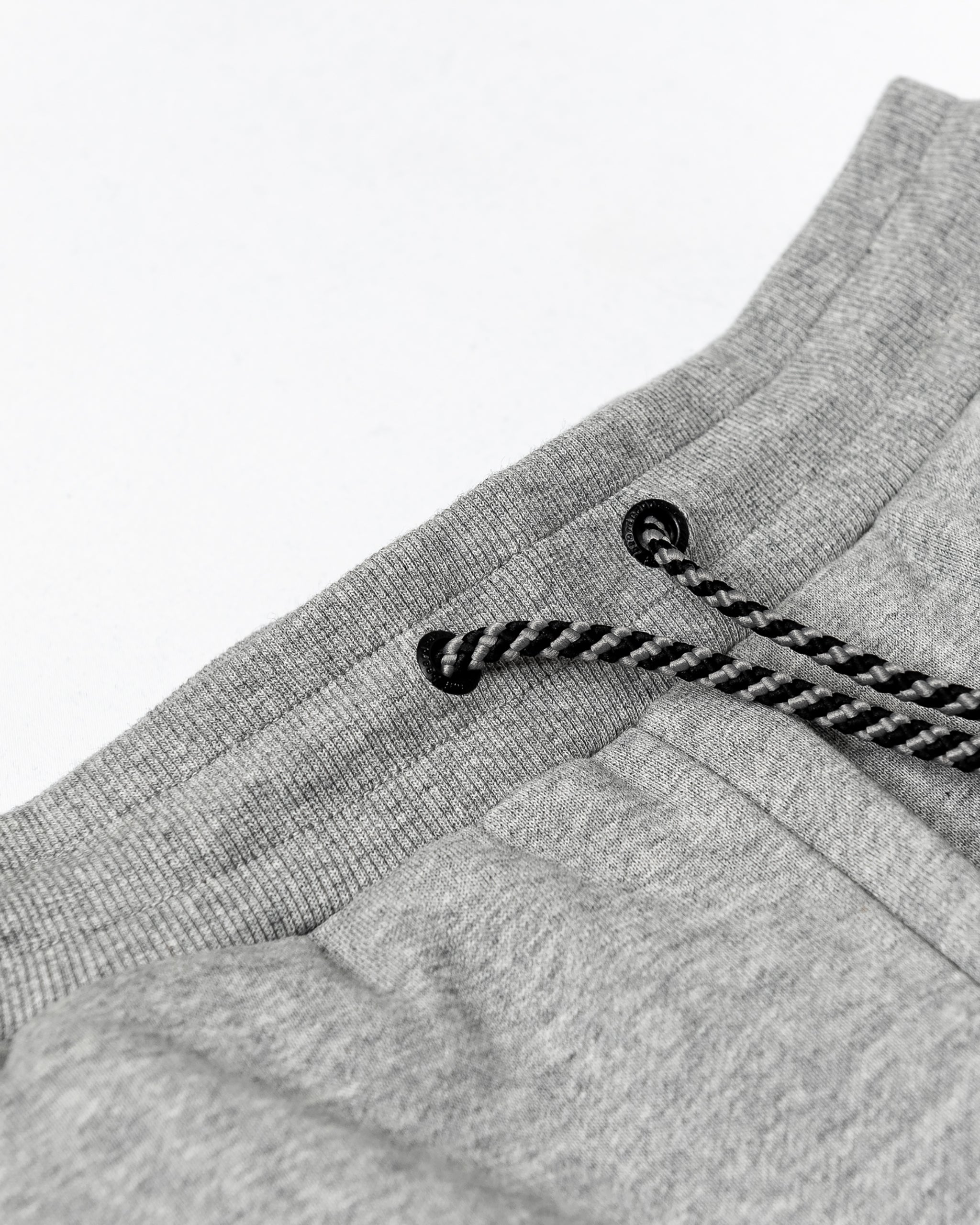 Close-up of the beardedgoat Women’s Overnight Sweatpant, made from heavyweight cotton fleece with a black-and-white braided drawstring threaded through metal eyelets and soft ribbed fabric for comfortable loungewear.