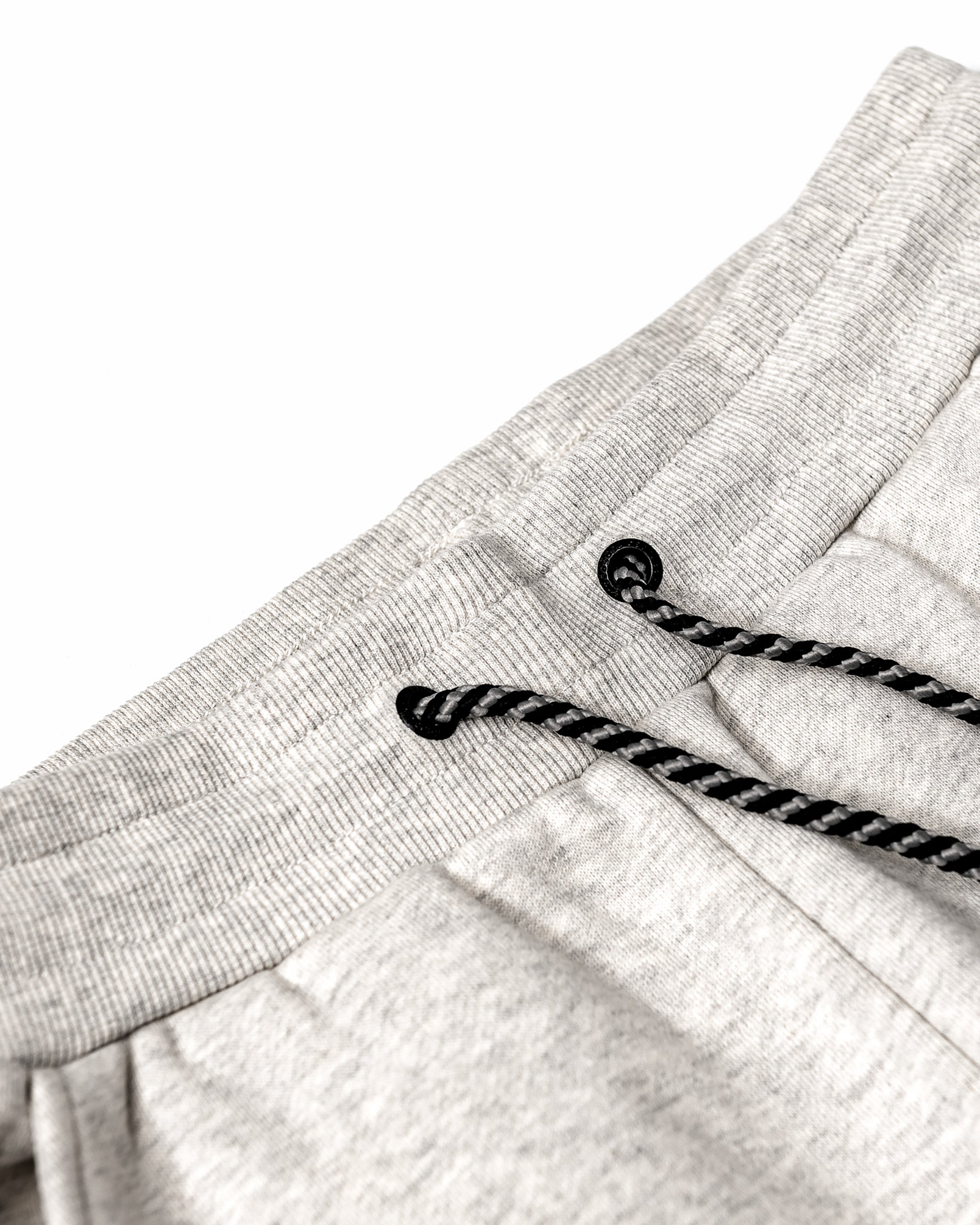 Close-up of the beardedgoat Women’s Overnight Sweatpant waistband in light gray heavyweight cotton fleece, featuring an elastic band and black-and-white drawstrings, shown against a white background.