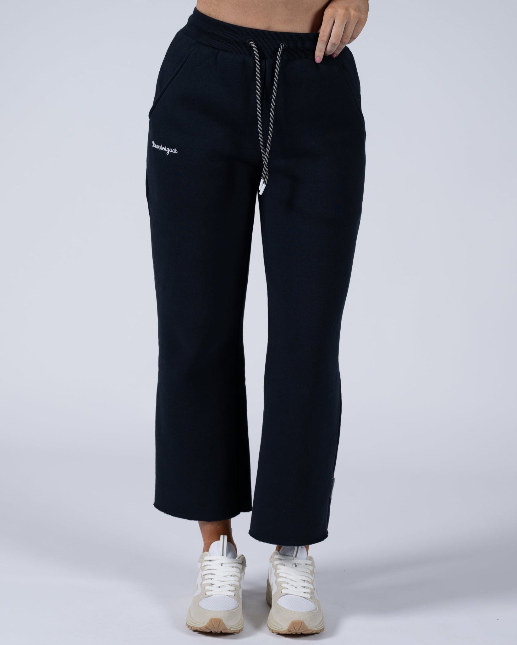 A person wears the beardedgoat Women’s Overnight Sweatpant, made from heavyweight cotton fleece with a relaxed fit and hip pockets, paired with white sneakers against a plain light background—ideal for comfortable loungewear.