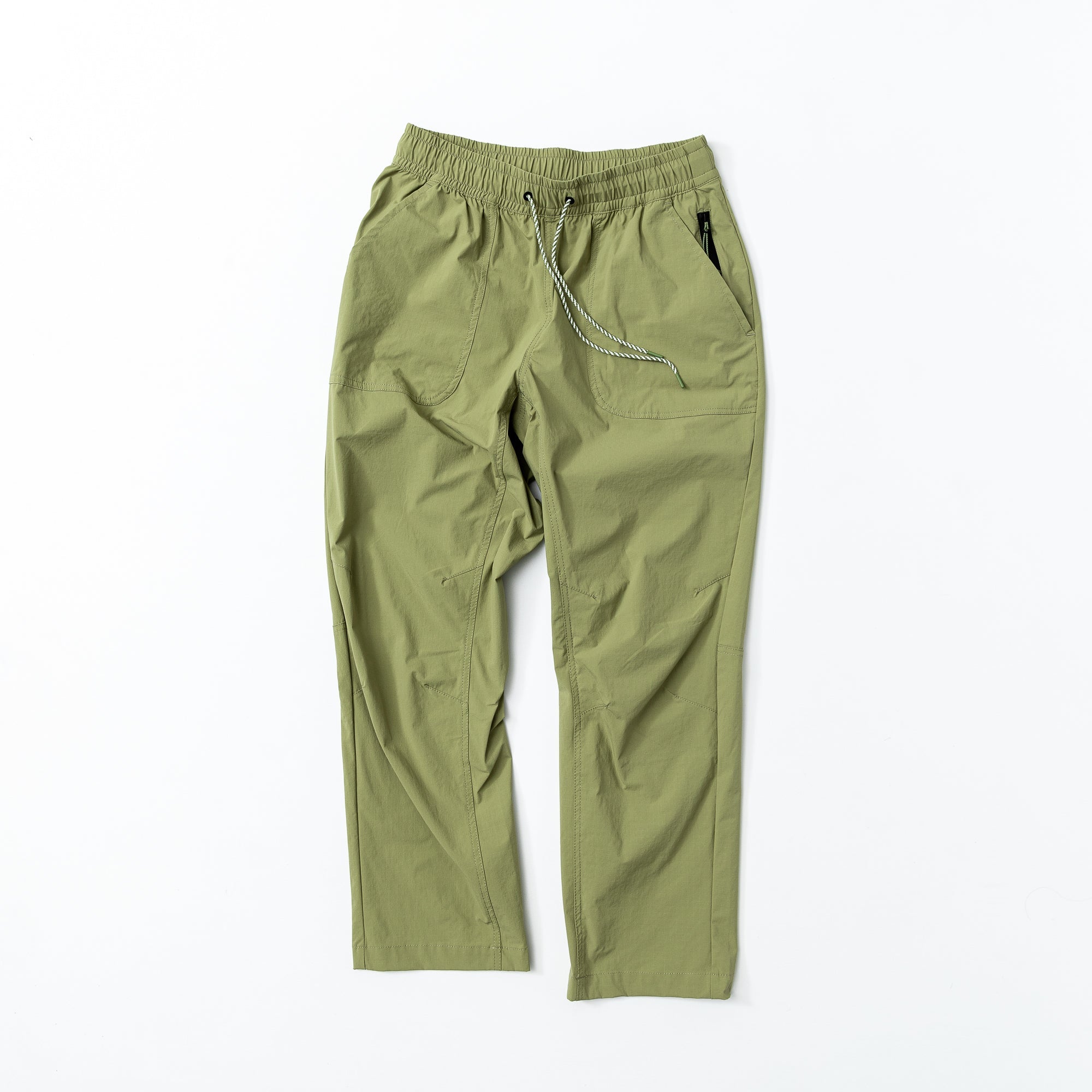 The beardedgoat Womens Summit Pant joggers in lightweight olive green feature an elastic waistband, drawstring, and side pockets, shown laid flat on a white background.