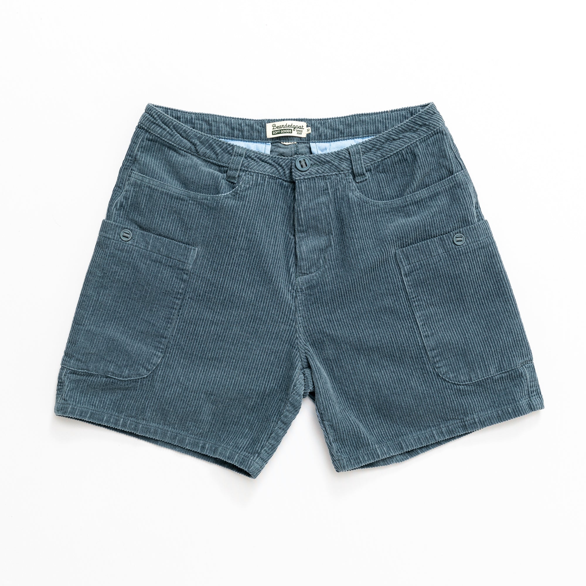 The beardedgoat Mens Moor Short in teal cotton corduroy features front cargo pockets and a button closure, shown flat on a white background.