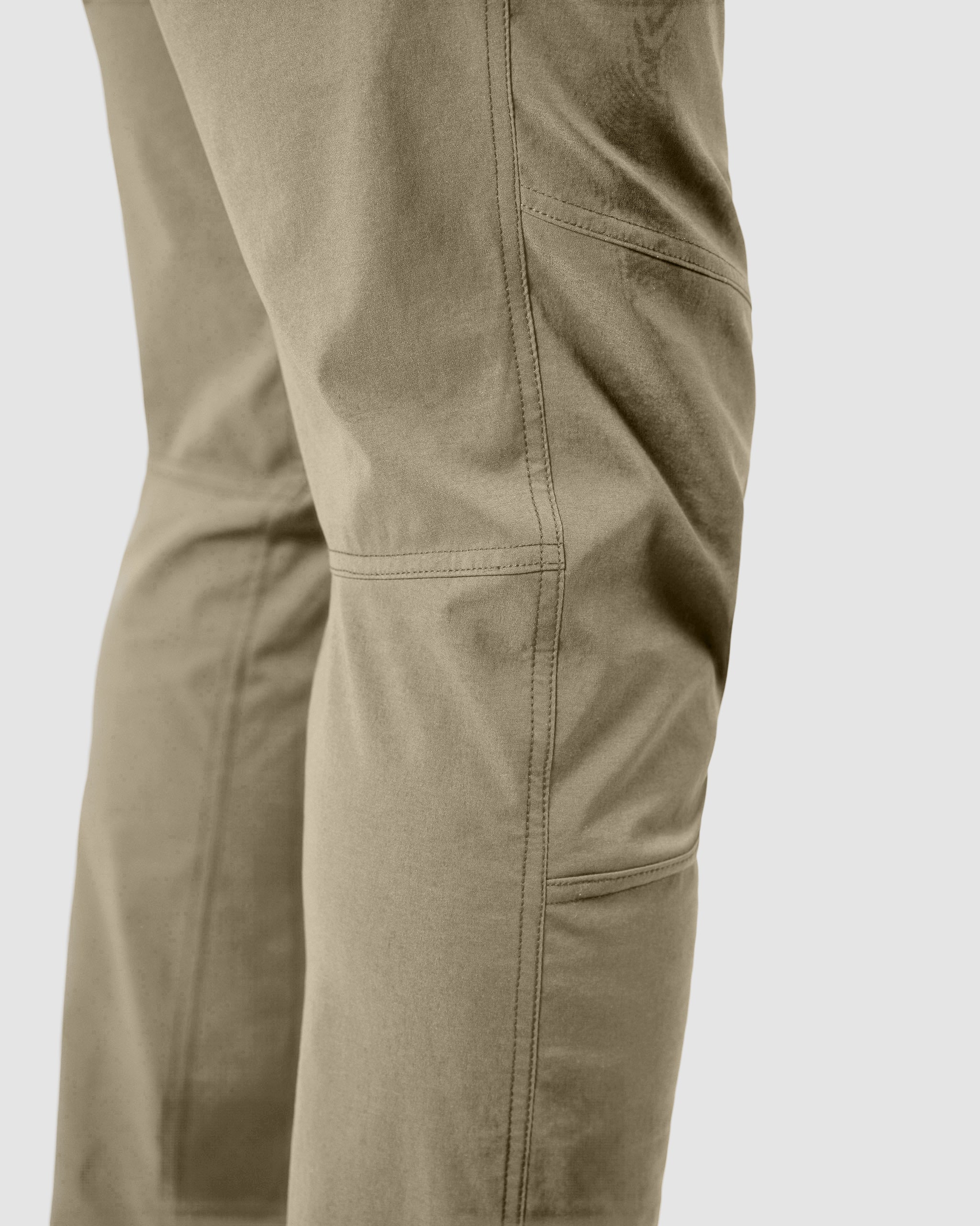 Close-up of a person wearing BEARDEDGOAT's NEW-—ROVER™ Pant, showcasing the durable construction with detailed stitching and seam design on the thigh and knee areas, set against a plain light background.