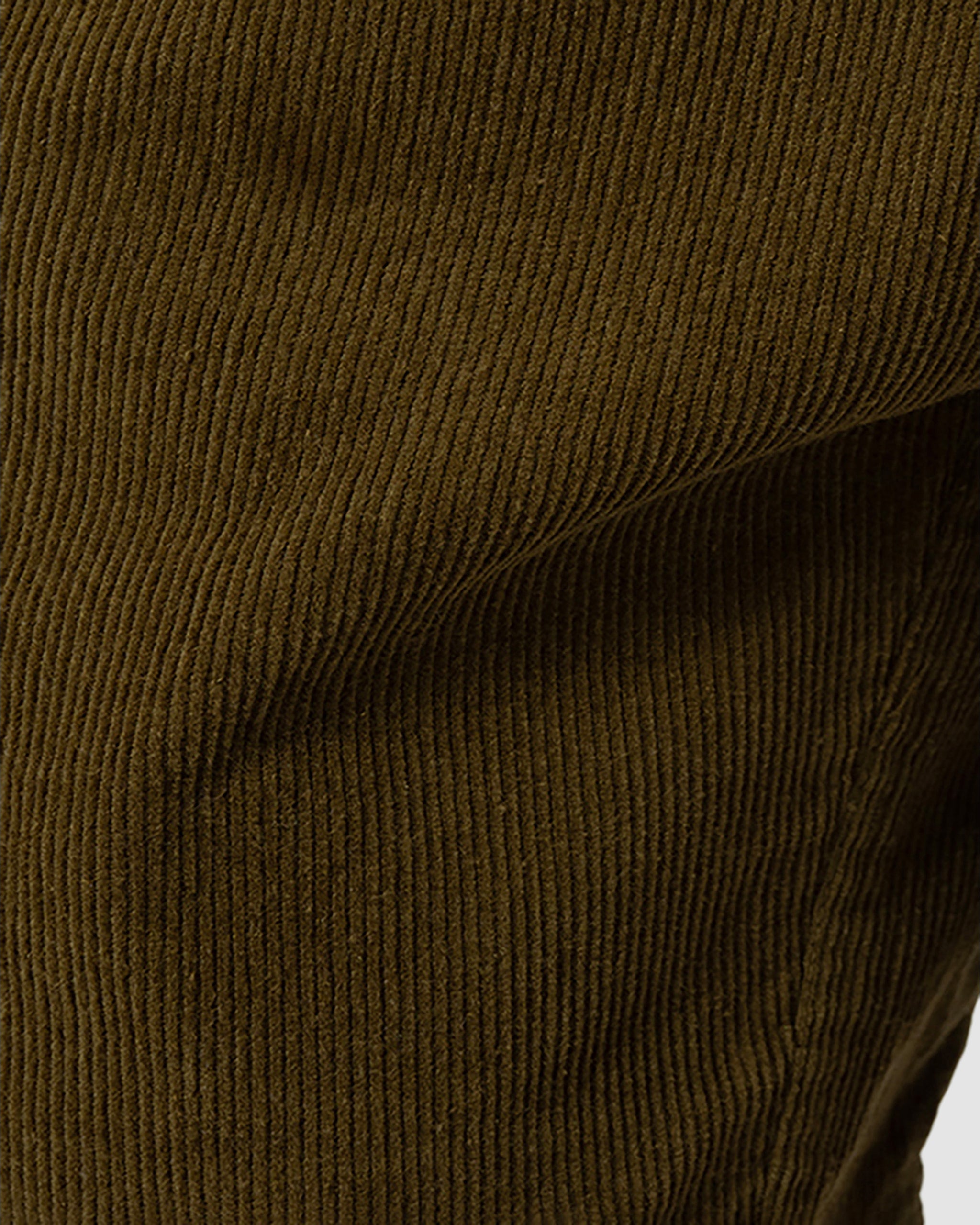 Close-up of brown corduroy fabric showcases its signature vertical ridges and softness—ideal for vintage-inspired style in your next BEARDEDGOAT Mens Cord Short.