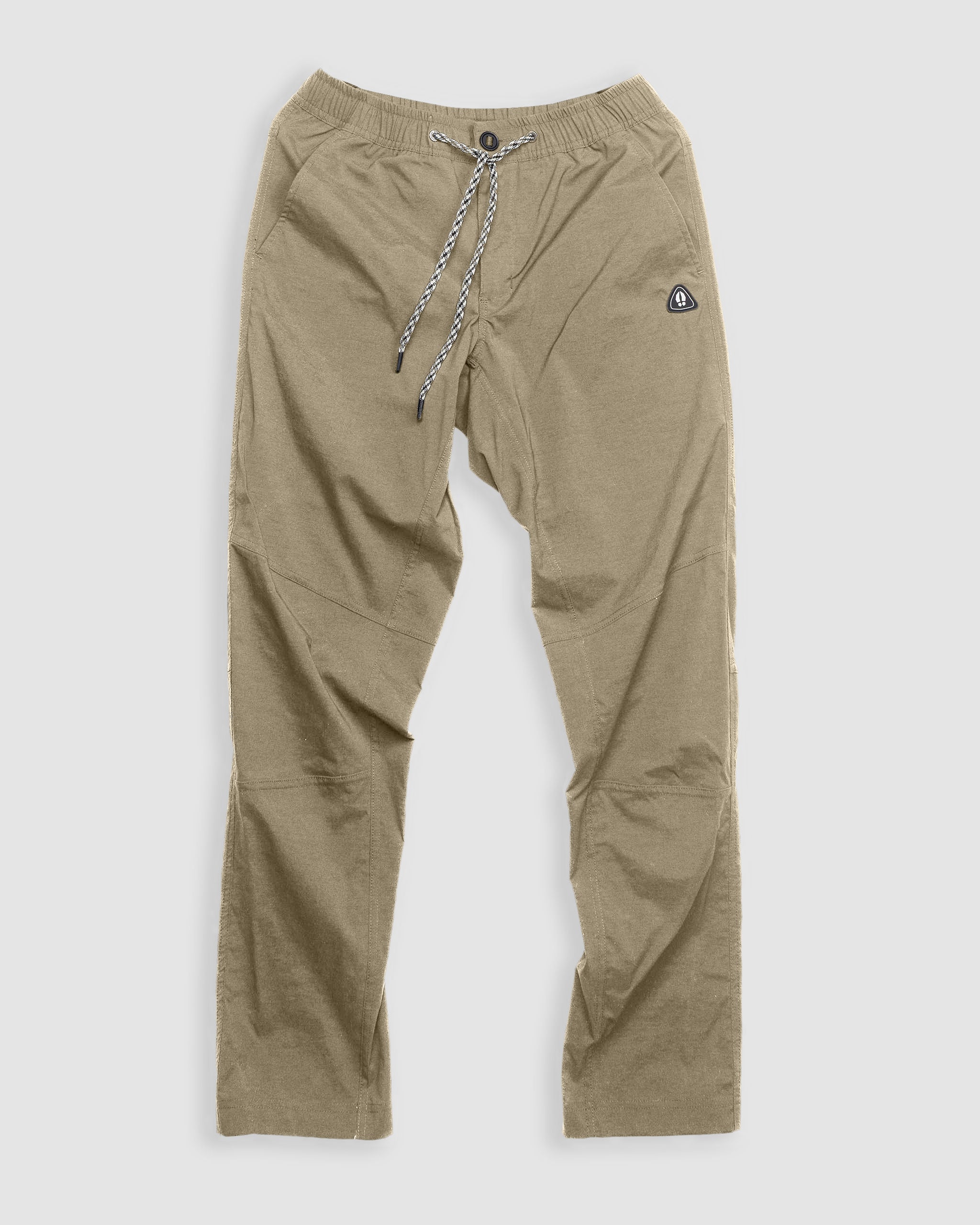 The BEARDEDGOAT NEW-—ROVER™ Pant in Terra Sienna is made from performance stretch nylon and features an elastic waistband, black-and-white shoelace drawstring, side pockets, and a small black patch logo on the upper left thigh.