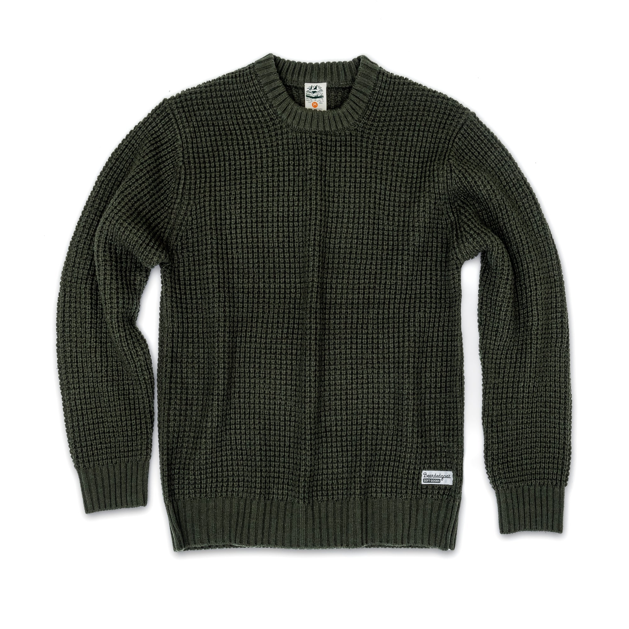 The beardedgoat Mens Odis Boatyard Sweater is a dark green, heavyweight winter knit with long sleeves, round neck, ribbed cuffs and hem, waffle texture, and a small white tag on the lower left hem. Shown against a white background.