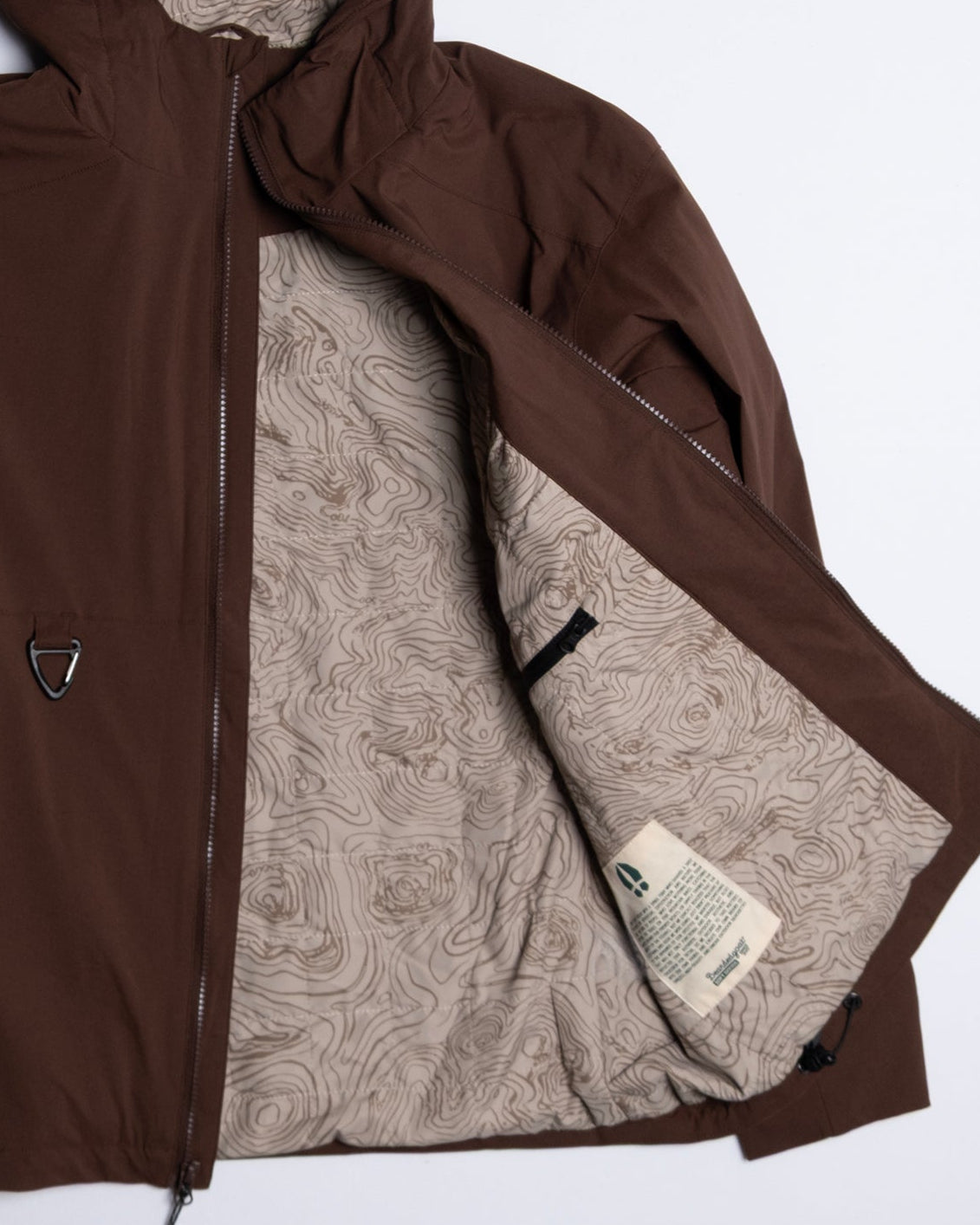 The beardedgoat NEW — OSLO Rover™ Performance All-Season Jacket features a brown exterior, unzipped front, and beige inner lining with a topographic map—ideal outerwear for any adventure.