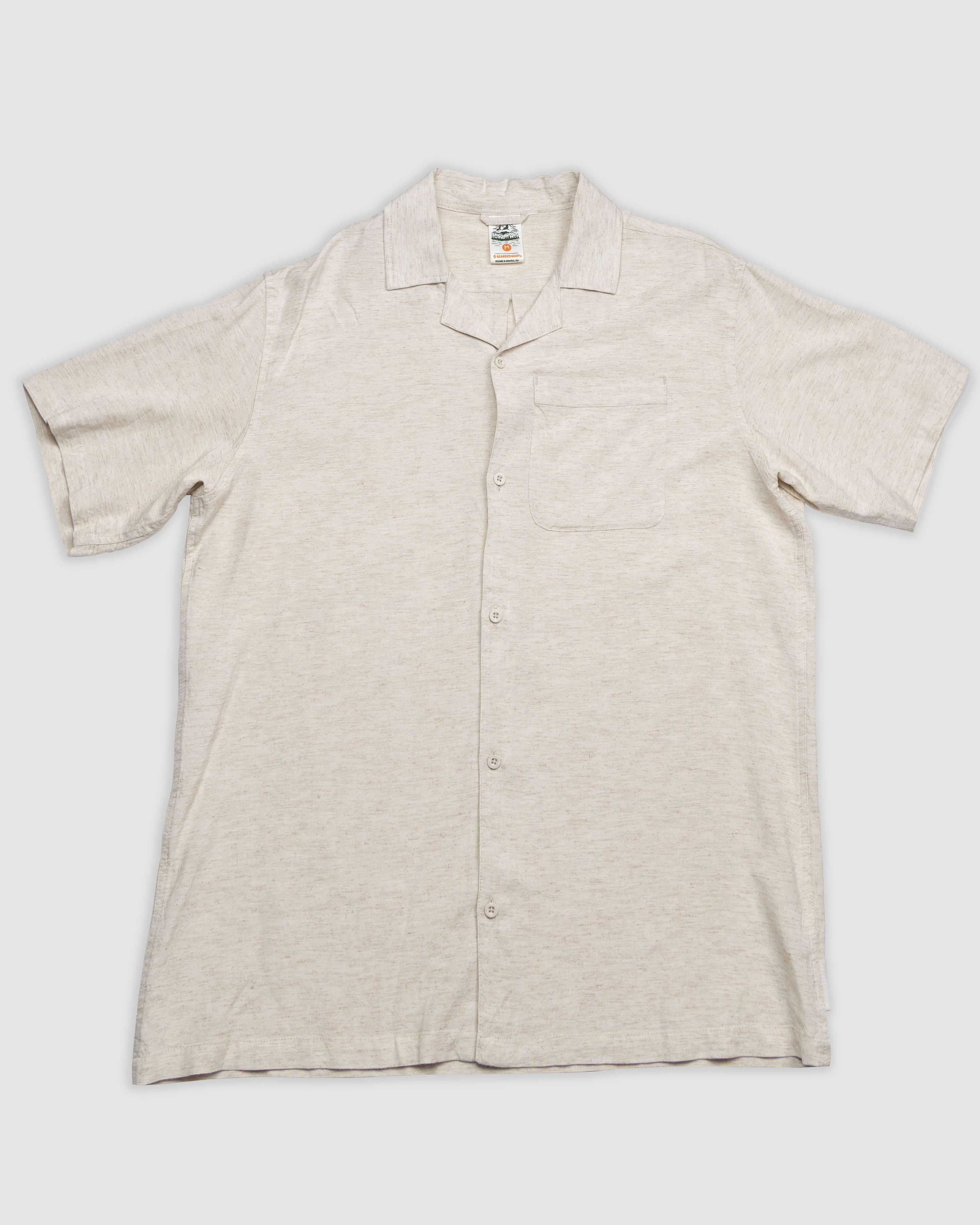 The BEARDEDGOAT Mens Breeze Shirt is a lightweight, short-sleeve linen shirt in light beige with a notched collar and chest pocket, shown laid flat on a plain white background for a breathable, comfortable look.