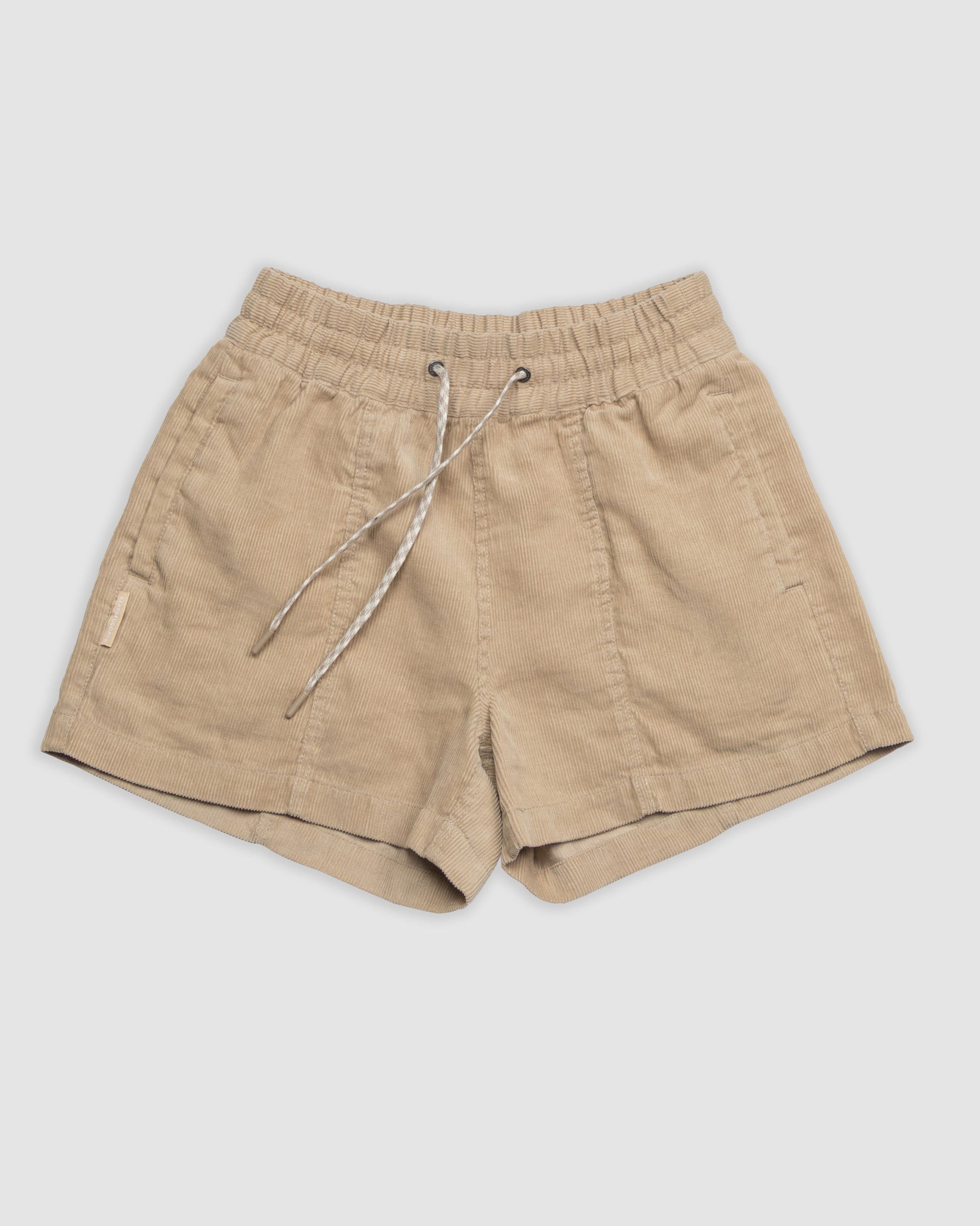 The BEARDEDGOAT Women's Cord Short, featuring a beige corduroy fabric, elastic waistband, white and gray drawstring, and side pockets, is displayed flat on a plain white background.