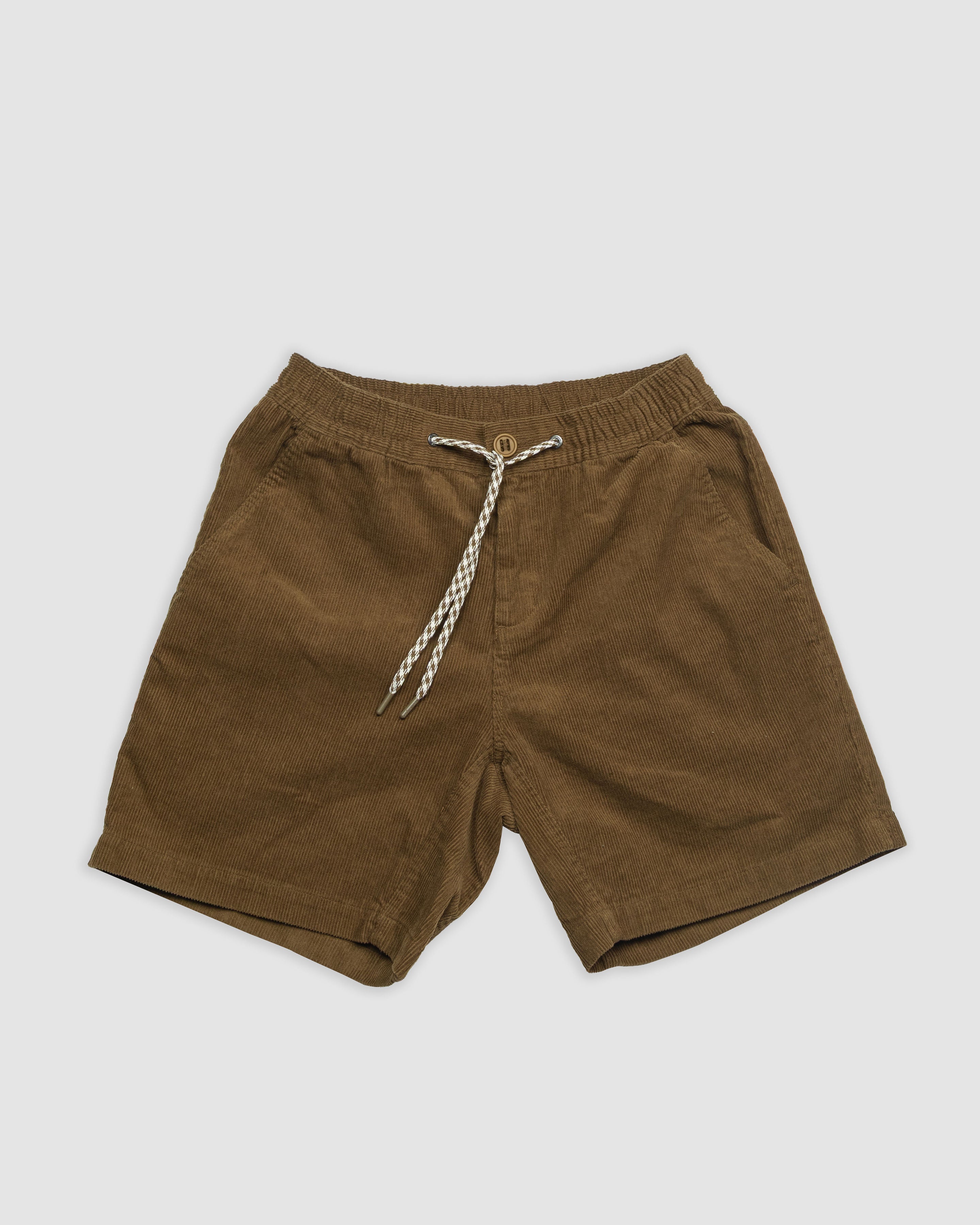 The BEARDEDGOAT Mens Cord Short, in brown corduroy with an elastic waistband and white-and-black drawstring, is displayed flat on a white background, combining everyday versatility with subtle vintage style.