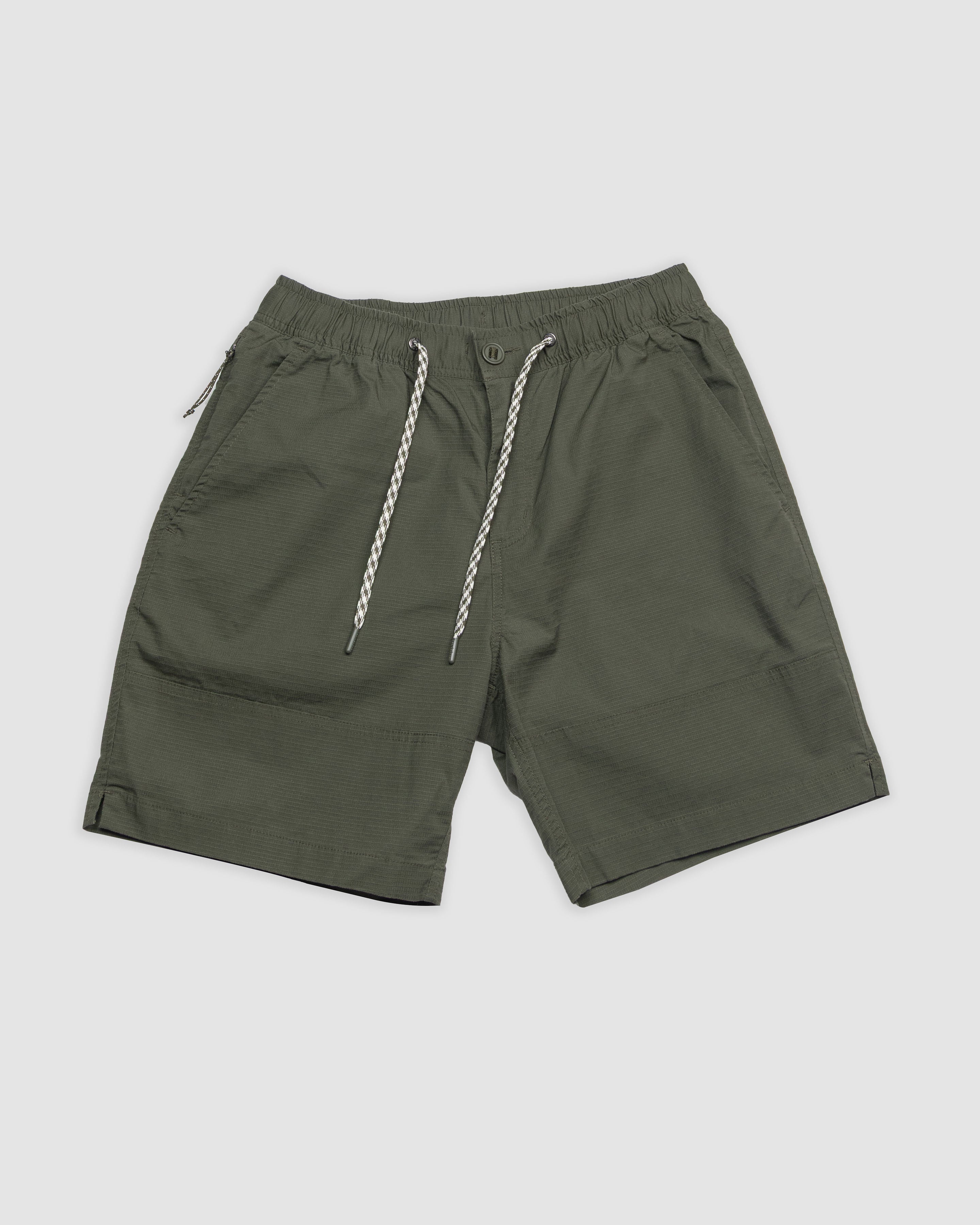 The BEARDEDGOAT Mens Canopy Short in olive green offers an elastic waistband, white and black drawstrings, side pockets, and lightweight breathable stretch cotton ripstop, shown against a light gray background.