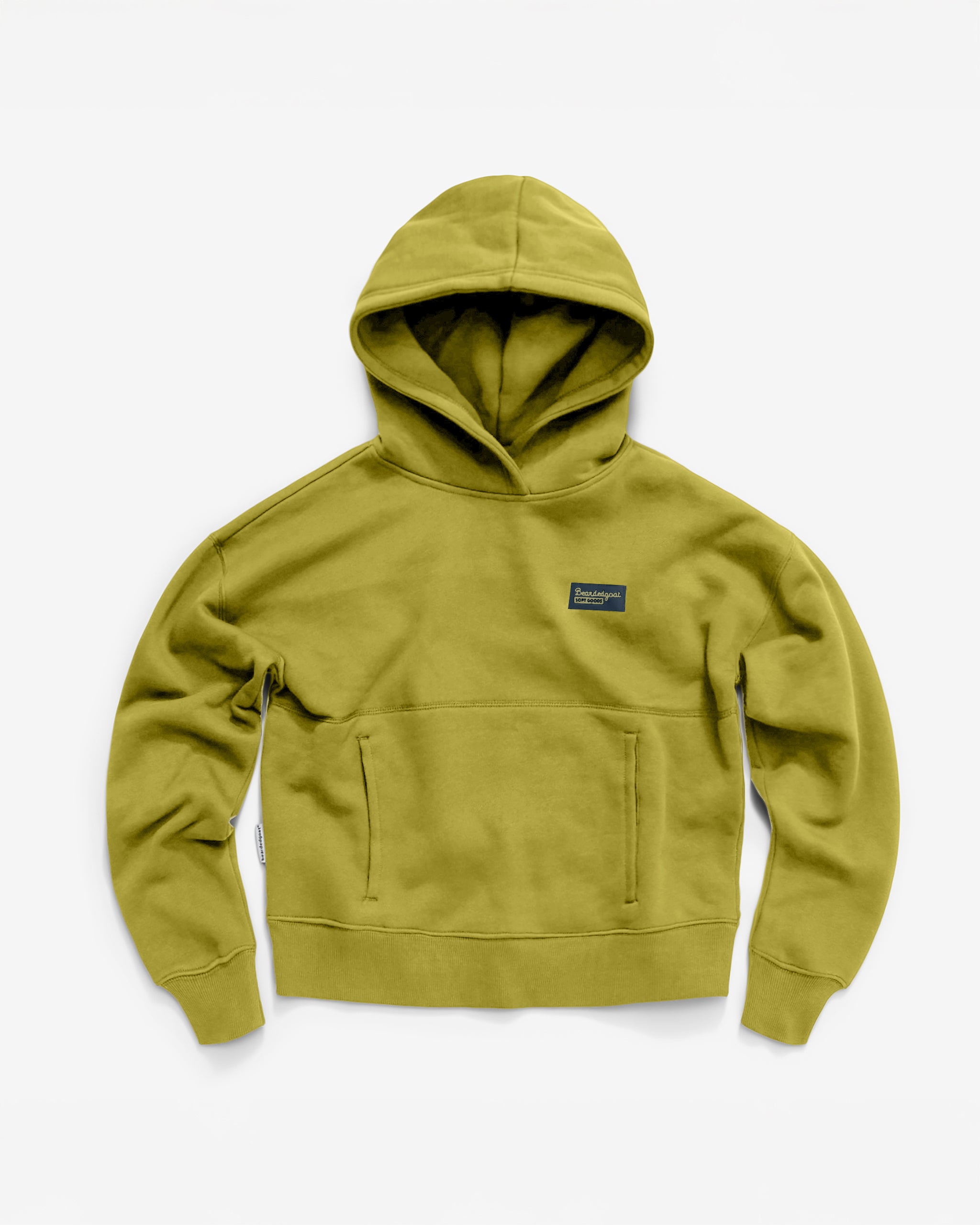 The beardedgoat Women's Overnight™ Hoodie in moss green is made from heavyweight cotton fleece, with long sleeves, a front kangaroo pocket, and a small rectangular patch on the left chest. The relaxed fit is shown laid flat on a white background.