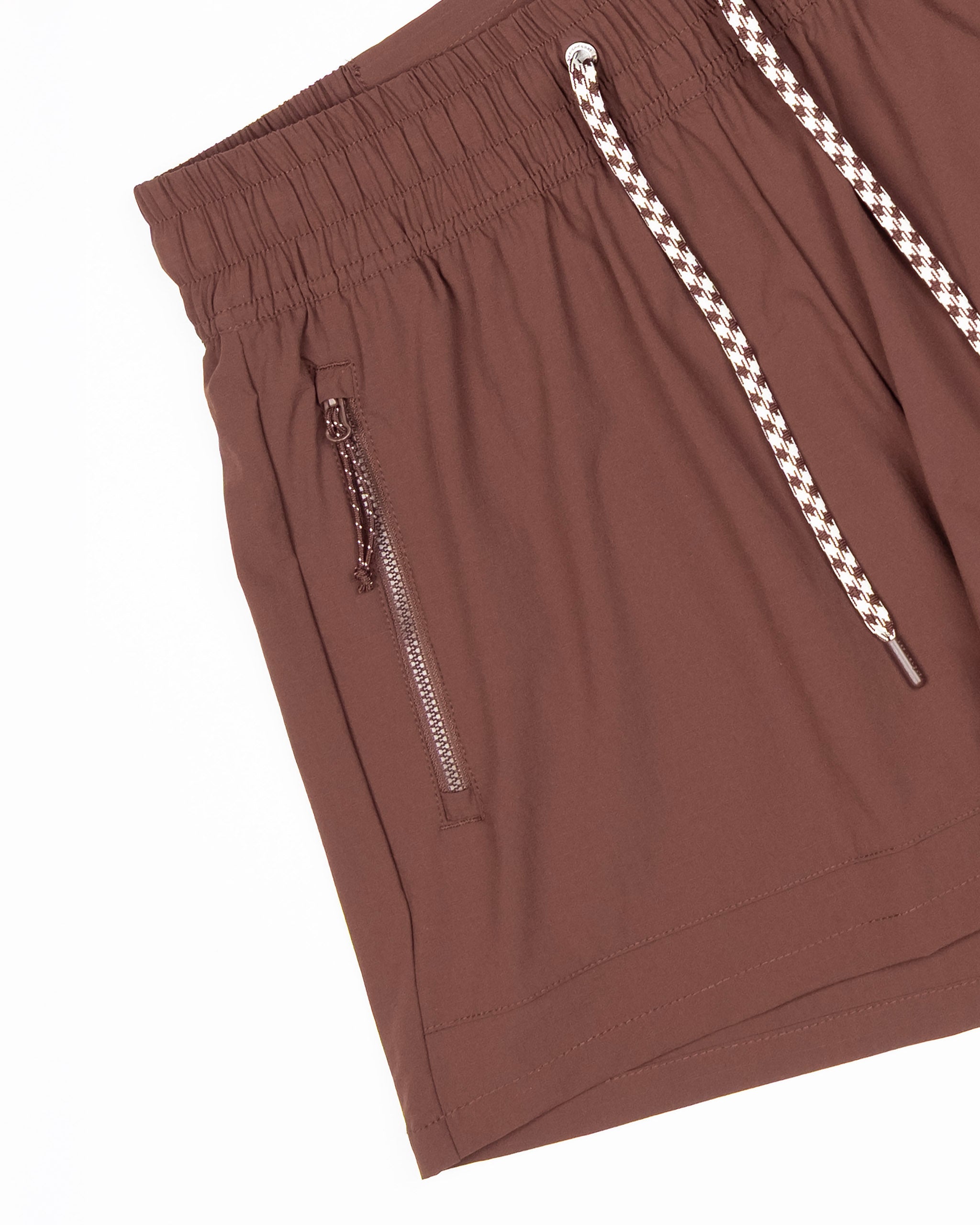 BEARDEDGOAT Women's Alpina Short in brown features a high-waisted fit, elastic waistband, white and brown braided drawstrings, ripstop fabric, and a zippered side pocket, displayed on a white background.